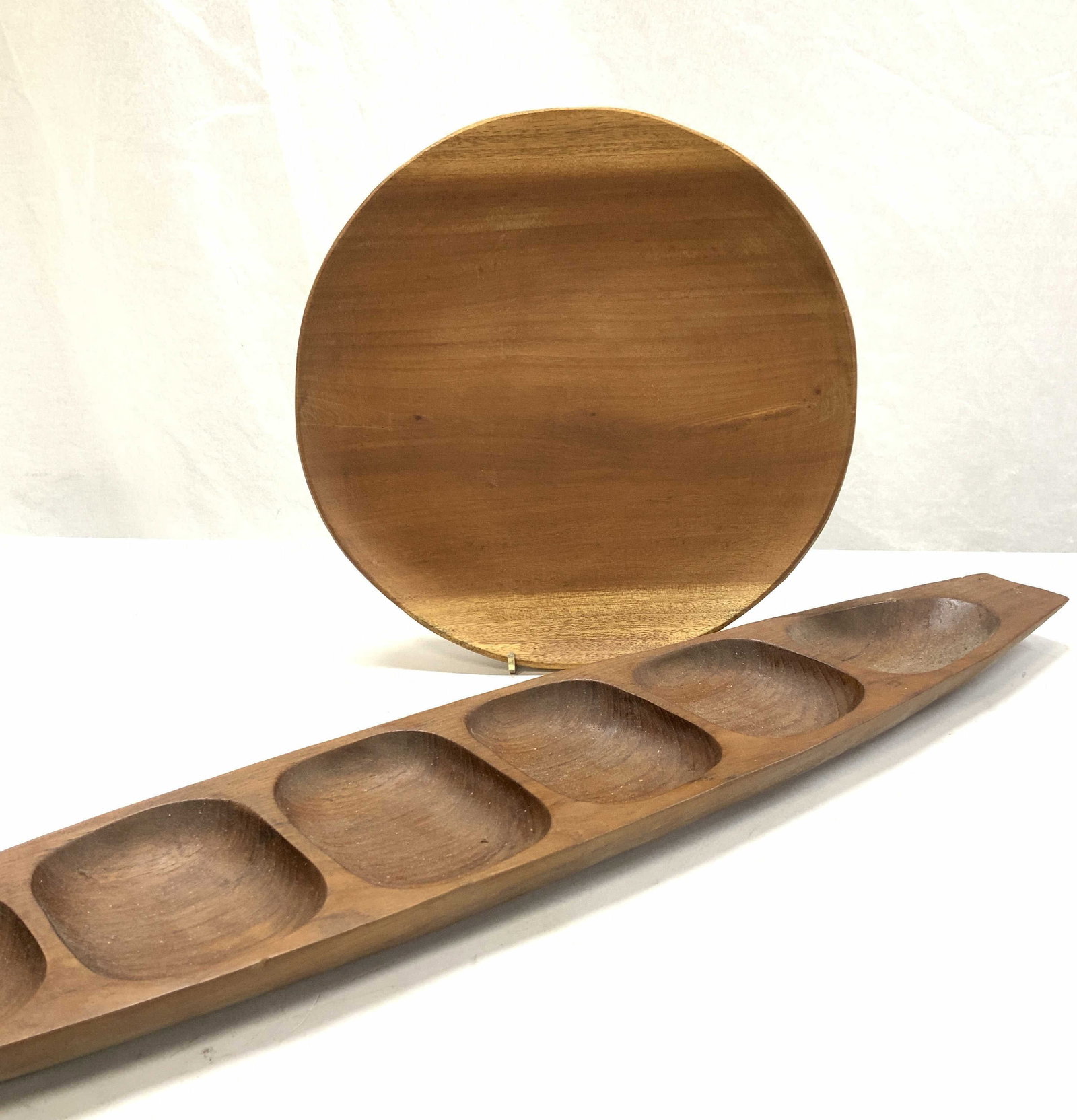 Teakwood Thailand, American W India Co Woodware: American West India Co Wood plate, used as a wall plate and has nails on the back. Labeled sticker. Possibly teak. Approx 10 in. Diameter. Hand made teakwood appetizer platter ( in the shape of a cano