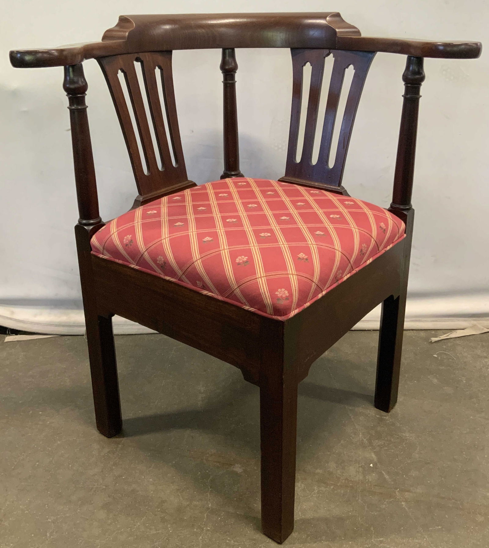 Vintage Chippendale Style Floral Uph Corner Chair: A vintage Chippendale style corner chair with a wooden frame that features a floral upholstery seat. Upholstery is red, yellow, pink, and green hues. Measures approx. 24.5D x 29W x 31.5H in. Some crac
