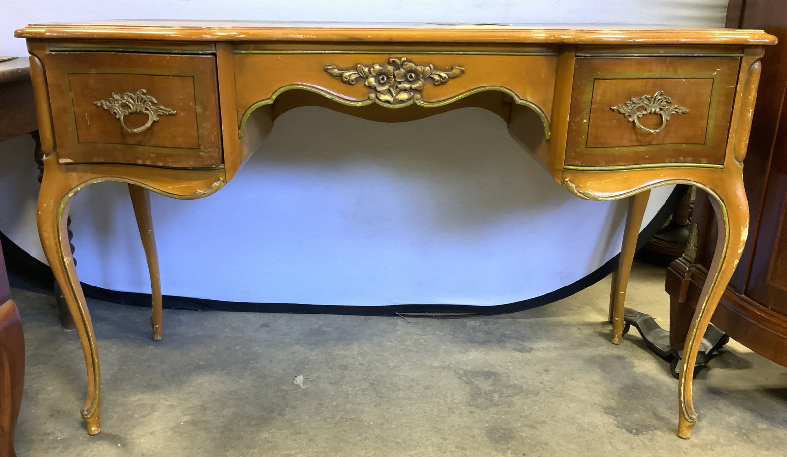 Vintage Wooden Queen Anne Desk W Drawers: Queen Anne leg desk. Piece is tan toned and wooden. Desk has gilt metal drawer pulls & gilt painted floral detail in center. Desk is vintage. Drawer have dovetailing. Piece measures approximately 48 i