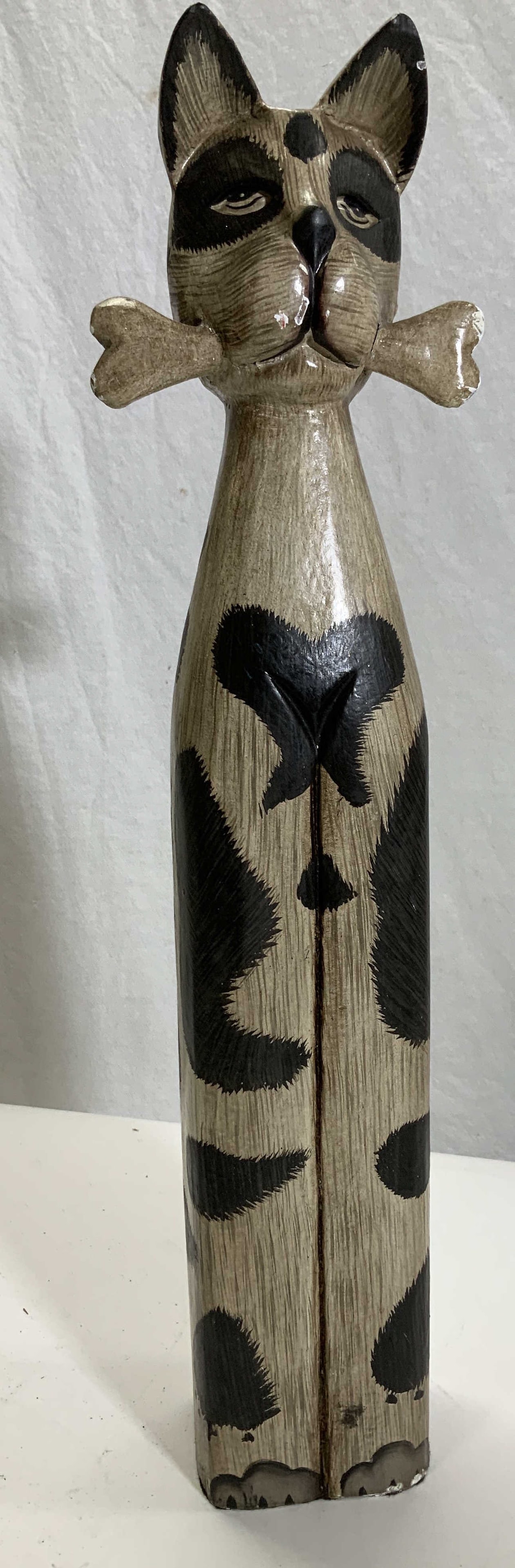 Folk Art Painted Dog Sculpture: Hand painted fold art in the form of a dog with a bone. Plastic composite. Lightweight. Has some chipping. 19.5 in. Tall x 5.5 in. Wide. Folk art dog, folk art table top and shelf decor, home decor an