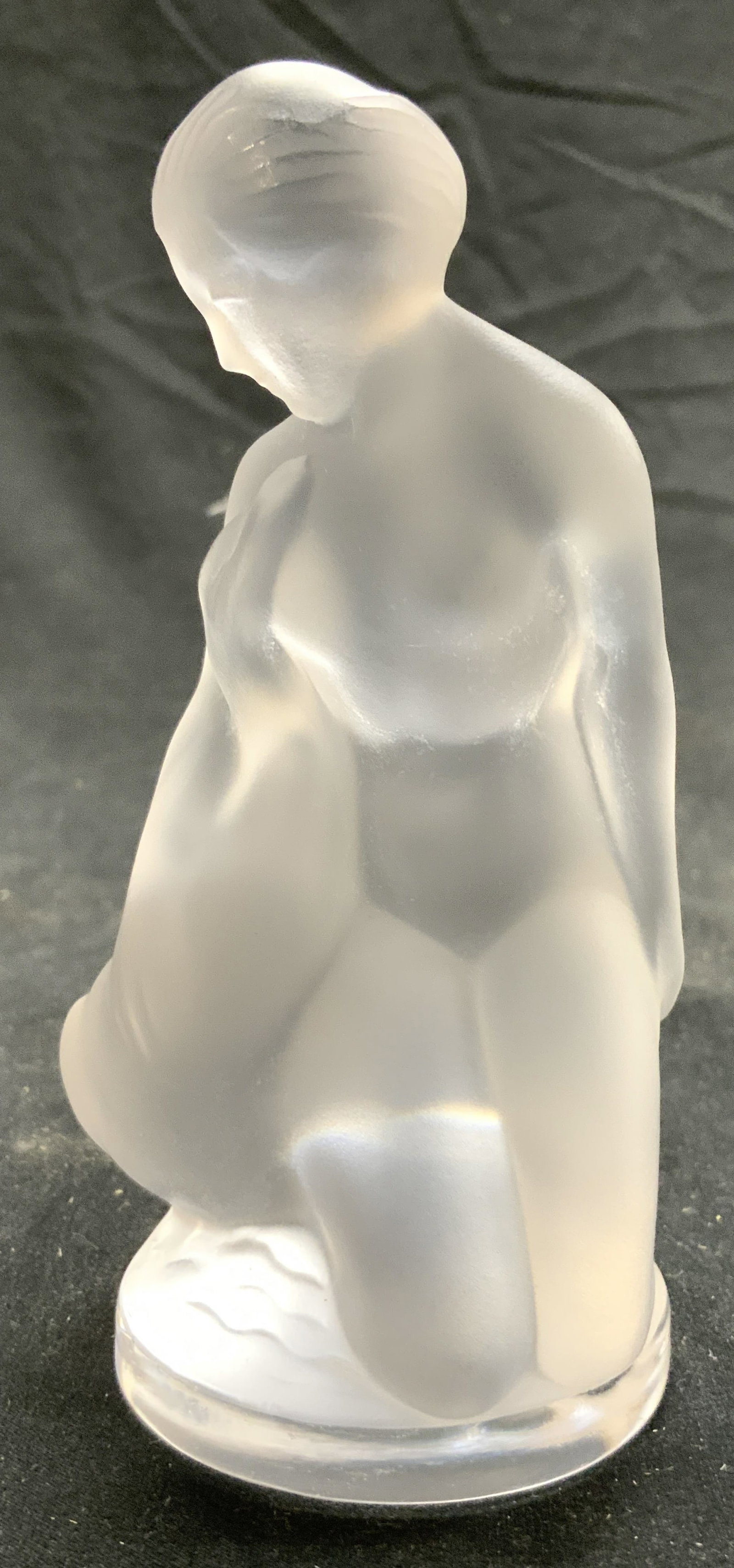 LALIQUE FRANCE LEDA & THE SWAN Female Nude: Underside is signed LALIQUE FRANCE. Piece depicts a kneeling female nude figure embracing a swan. Figure is crystal with frosted finish. Piece has circular shaped base. Figure measures approximately 4