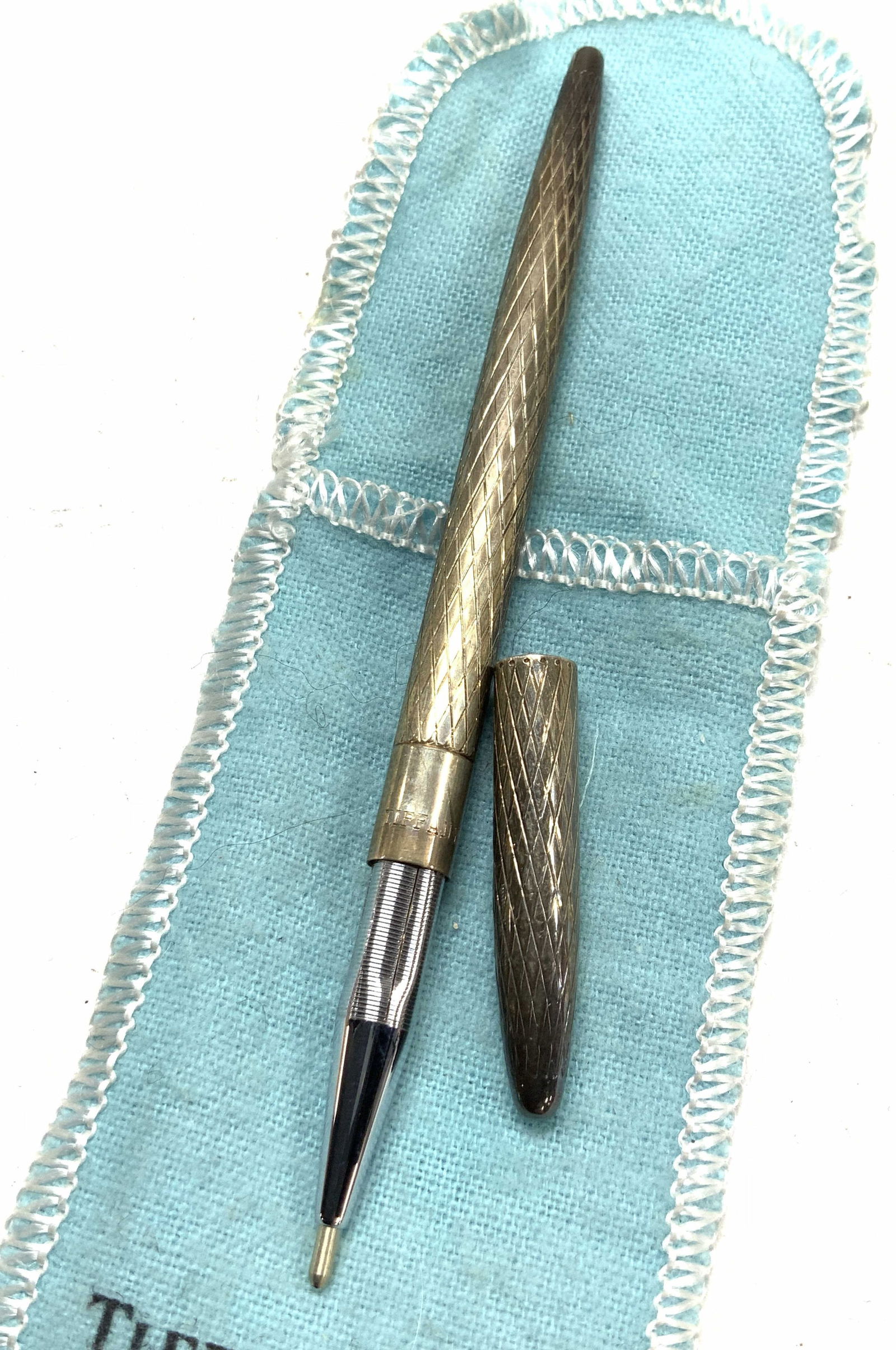 TIFFANY & Co STERLING SILVER PEN w Pouch +: Signed Tiffany & Co diamond cut sterling silver pen, 4.5 in. Long. Removable cap. Reds Tiffany & Co. & Sterling Silver. .23 ozt., comes with a Tiffany & Co Pouch and several lead drawing pencil filler