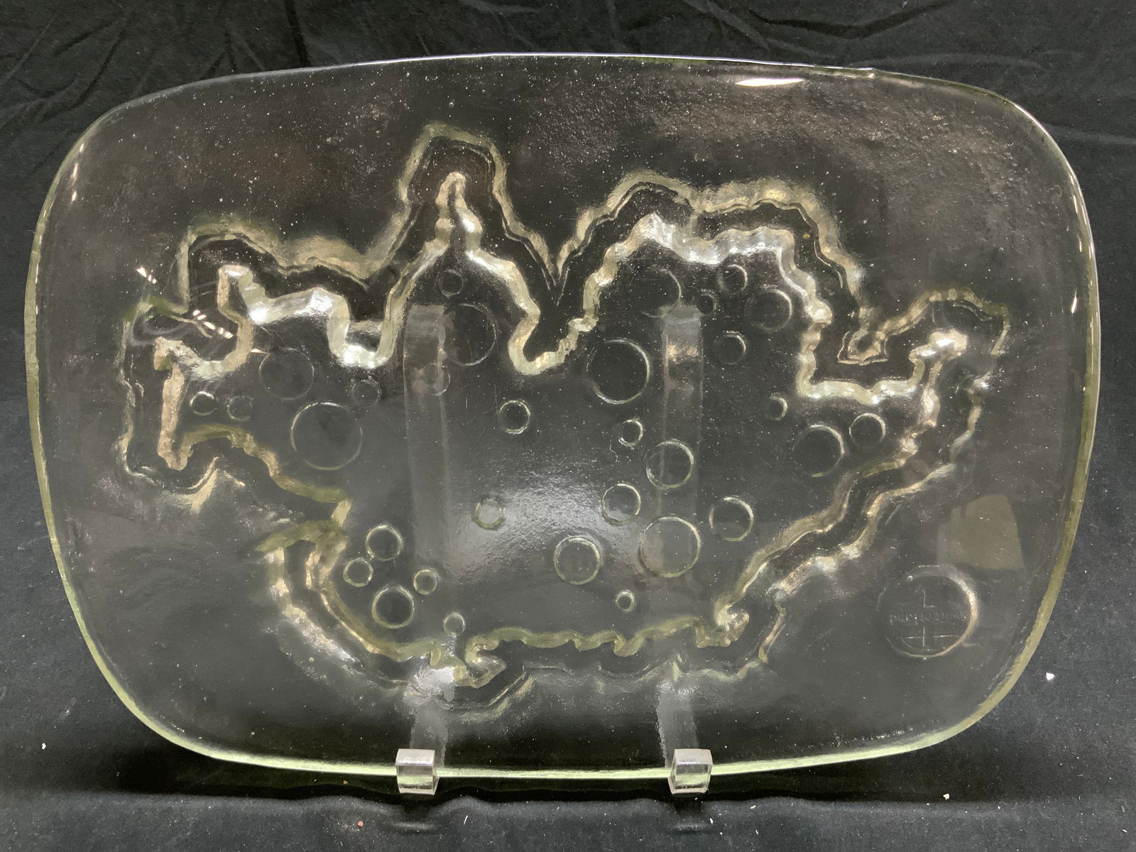 SWITZERLAND Thick Art Glass Trivet: Underside reads SWITZERLAND. Trivet is glass. Piece is thick walled. Trivet has detail in the shape of Switzerland. Piece has rounded rectangle form. Trivet measures approx 14 inches long 10 inches wi