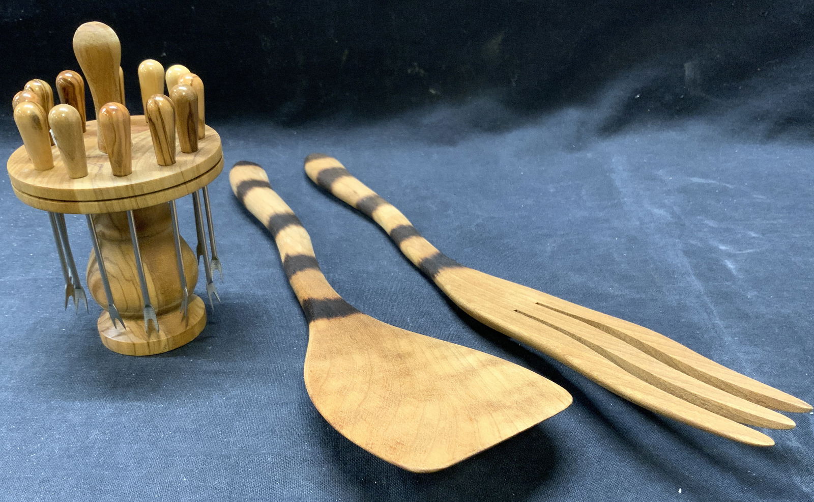 Lot 15 Hors D Oeuvres Forks & Salad Serv Utensils: Lot includes 14 hors forks, holder, and salad serving spatula & fork. Each piece is tan toned and wooden. Salad serving fork has wavy prongs. Largest piece measures approximately 14 inches long 2 inch