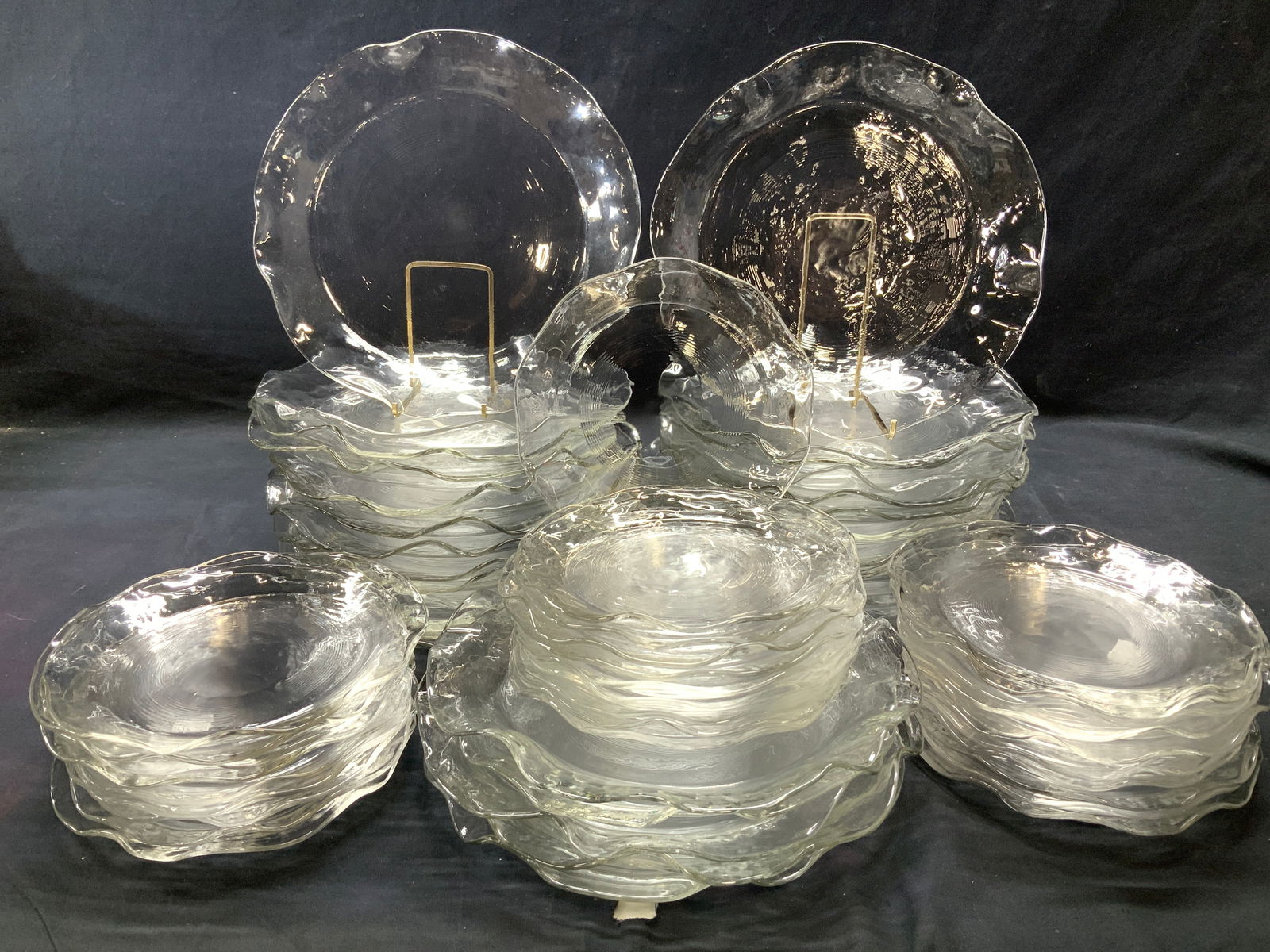 Blown Art Glass Plate Set 61: Clear art glass plate set. Blown glass with high and low relief undulations. Each plate has a slightly different edge. Set consists of 31 dinner plates 10.75 in. Diameter and 30 luncheon plates 8 in.