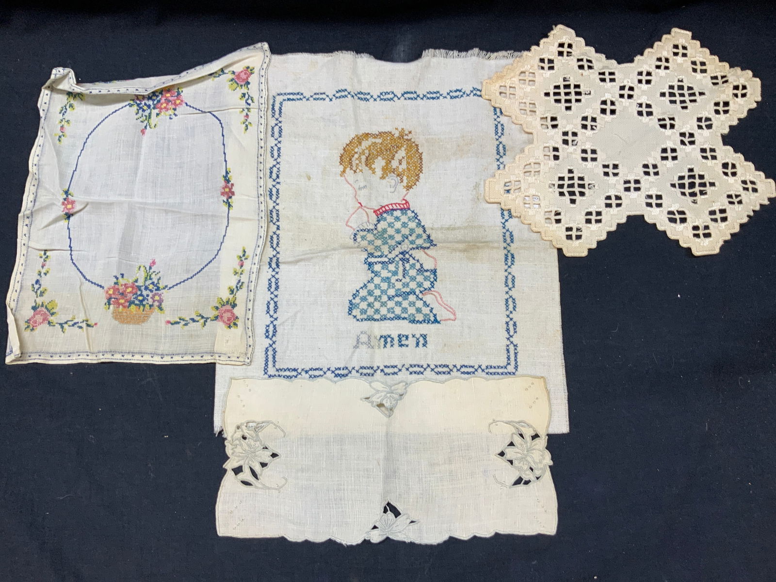Lot 4 Vntg Embroidery & Cross Stitch Linens: Lot of 4 vintage linens and doilies. Embroidered and cross stitched. Largest towel depicting a praying child in cross stitching with the word Amen, approx 14 x 11.5 inches. 1 table mat with cross stit
