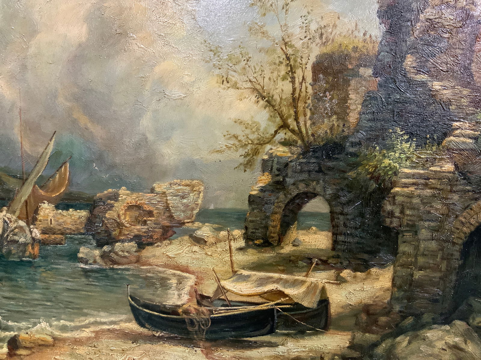 Framed Ruins on Beach Dunes Oil Painting: Oil paint on canvas. Subject depicts a scene of boats and sails across the ruins of a coastal castle. Framed in gilt wooden frame with raised scrolling patterned motifs. Frame measures approx. 32 W in