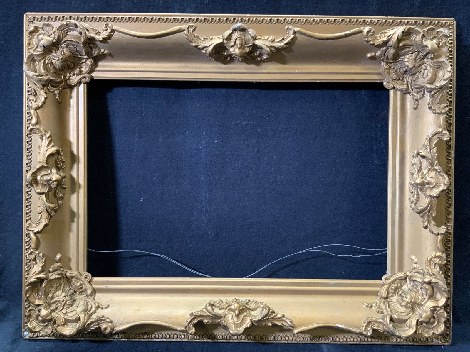 Gilt Wooden Frame with Scrolling Molding: Gilt wooden frame with scrolling and foliage molding. Outer edge has raised patterned motif. Frame measures approx. 25 W x 19.5 H in. Window measures approx. 17.5 W x 11.5 H in. Not viewed outside of 