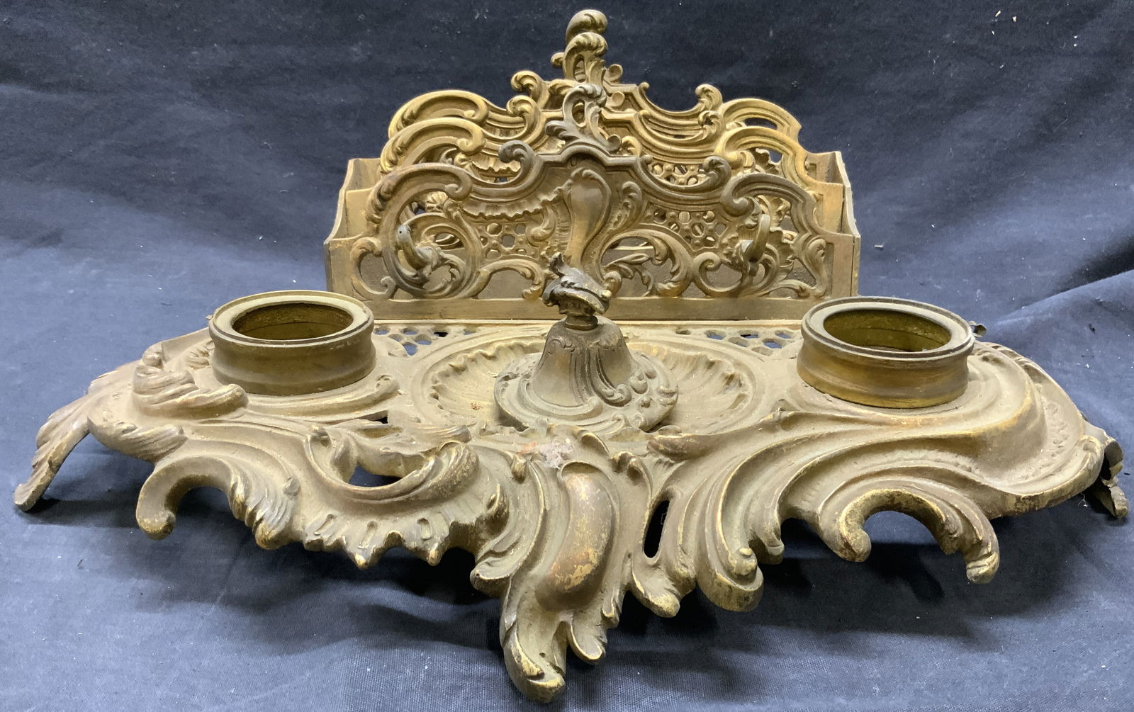 Antique Brass Victorian Inkwell W Letter Holder: Inkwell appears to be antique possibly vintage. Piece has intricate ornate scroll & leaf detail. Inkwell has letter holder at top. Piece is footed. Measures approximately 16 inches wide 6.25 inches ta