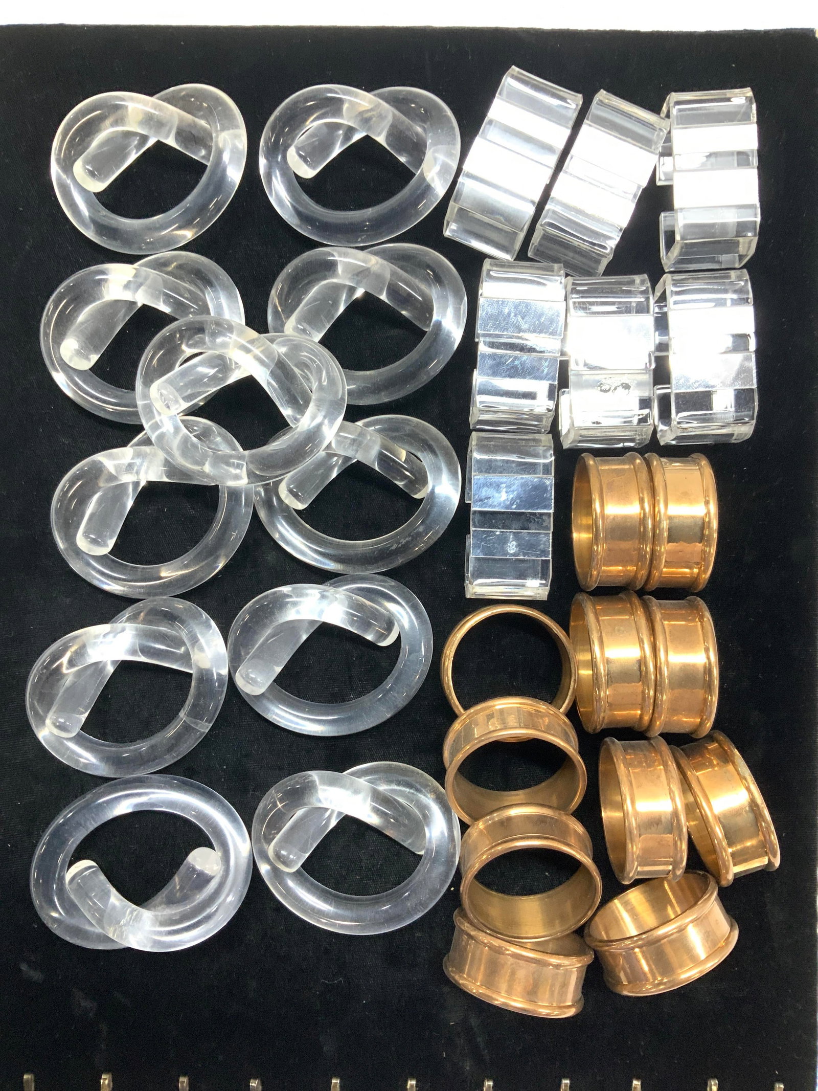 Group 30 Acrylic & Metal Napkin Ring Sets: Set 12 pretzel knot - style acrylic napkin rings, measure 3 x 2.25 in., Set 11 round metal napkin rings, 5/8 in. Wide x 1.75 in. Diameter. Set 7 acrylic napkin rings with mirror inserts. One piece lac