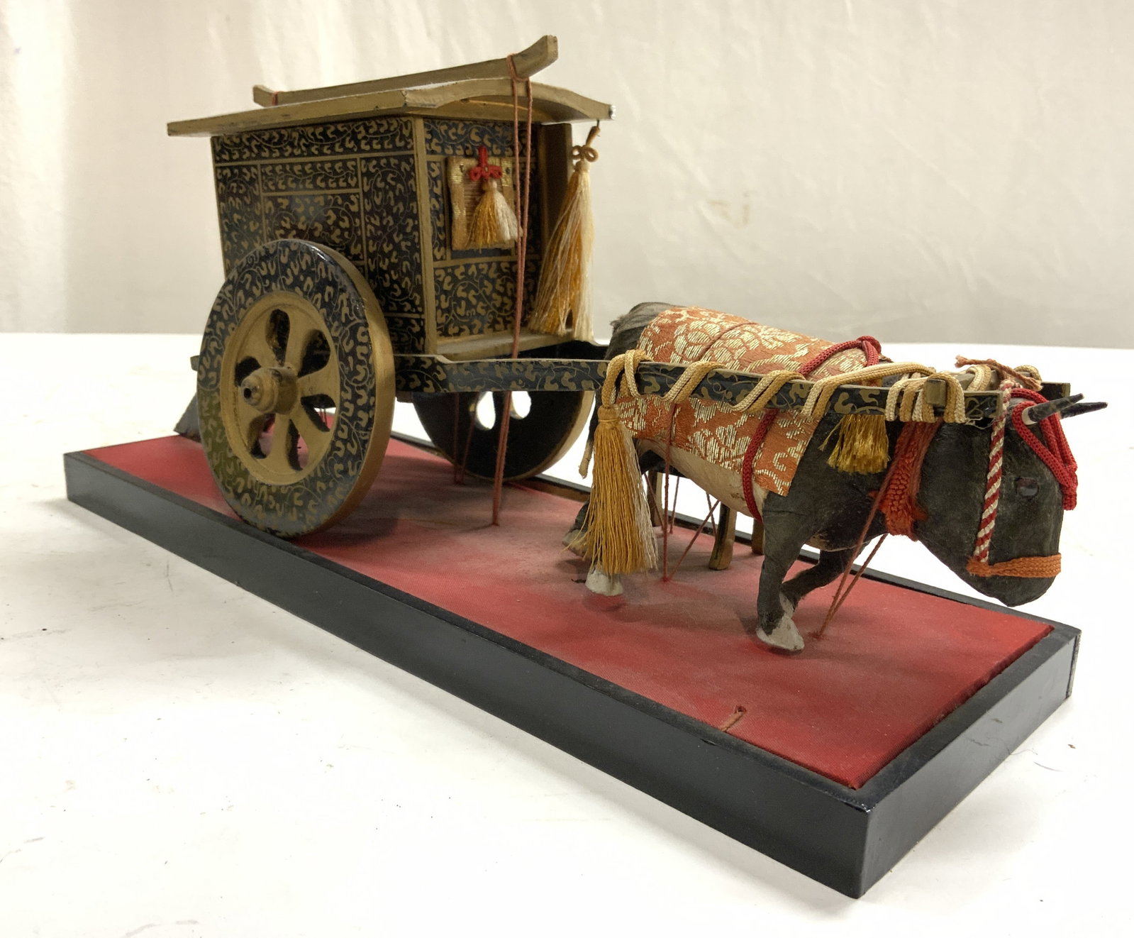 Vtg Asian Ceremonial Ox Carriage Figural: Figure is vintage. Piece depicts an ox pulling a ceremonial carriage. Figure is lacquered. Asian figural with gilt pattern detail to cart. Piece measures approximately 12.5 inches long 6 inches tall 4