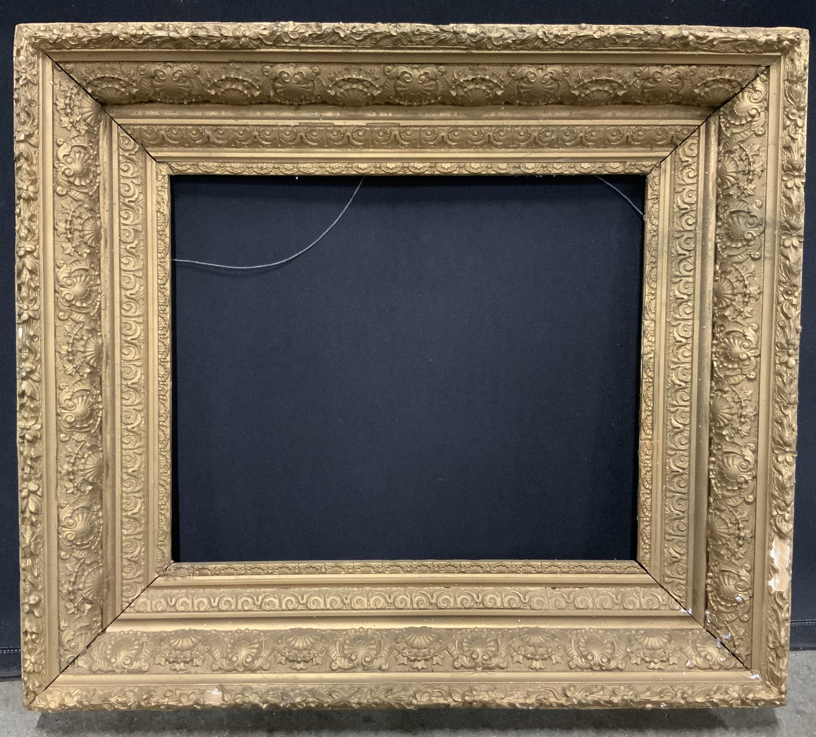 Gilt Wooden Frame with Floral Molding 26in: Gilt wood frame. Raised molding in scrolling, chain link, seashell, and floral motifs. Frame measures approx. 26 W x 24 H in. Window measures approx. 16.5 W x 13.5 H in. Not viewed hung. Frame has los
