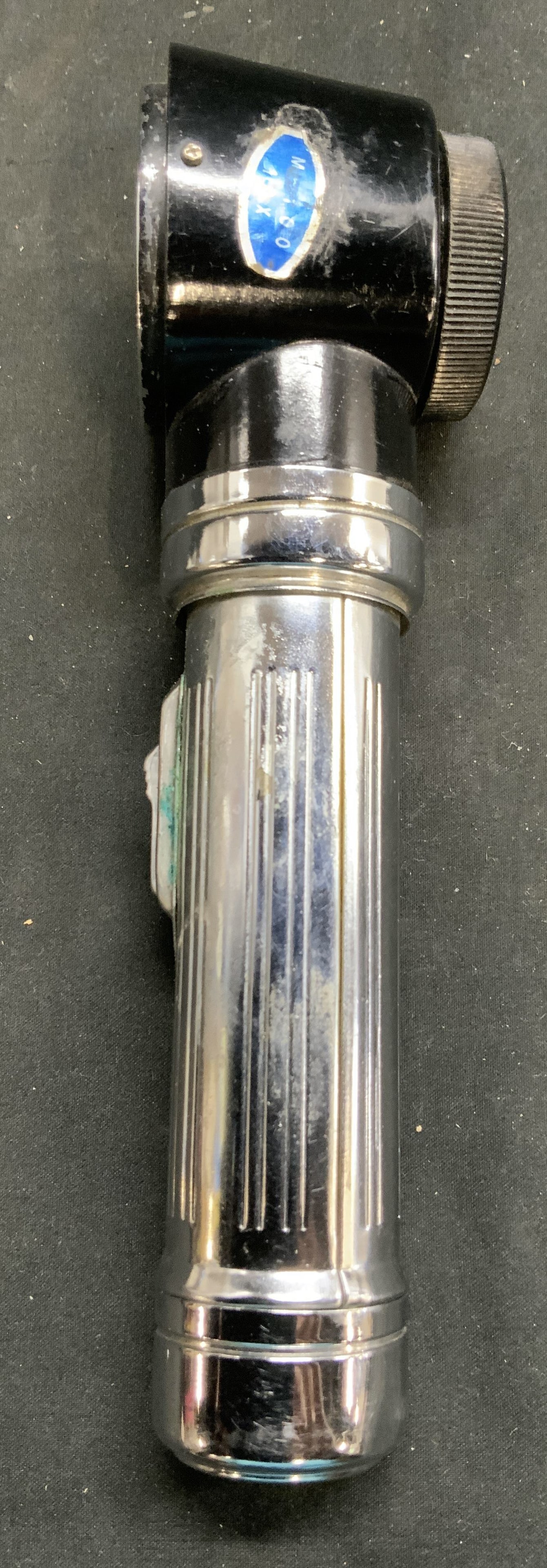 Vintage Metal Flashlight Magnifier 10x: Flashlight magnifier is vintage. Piece is black and silver toned. Tag reads 10X. Handle has switch. Piece measures approx 7 inches tall 2 inches deep 1.5 inch wide. Flashlight magnifier, vintage flash