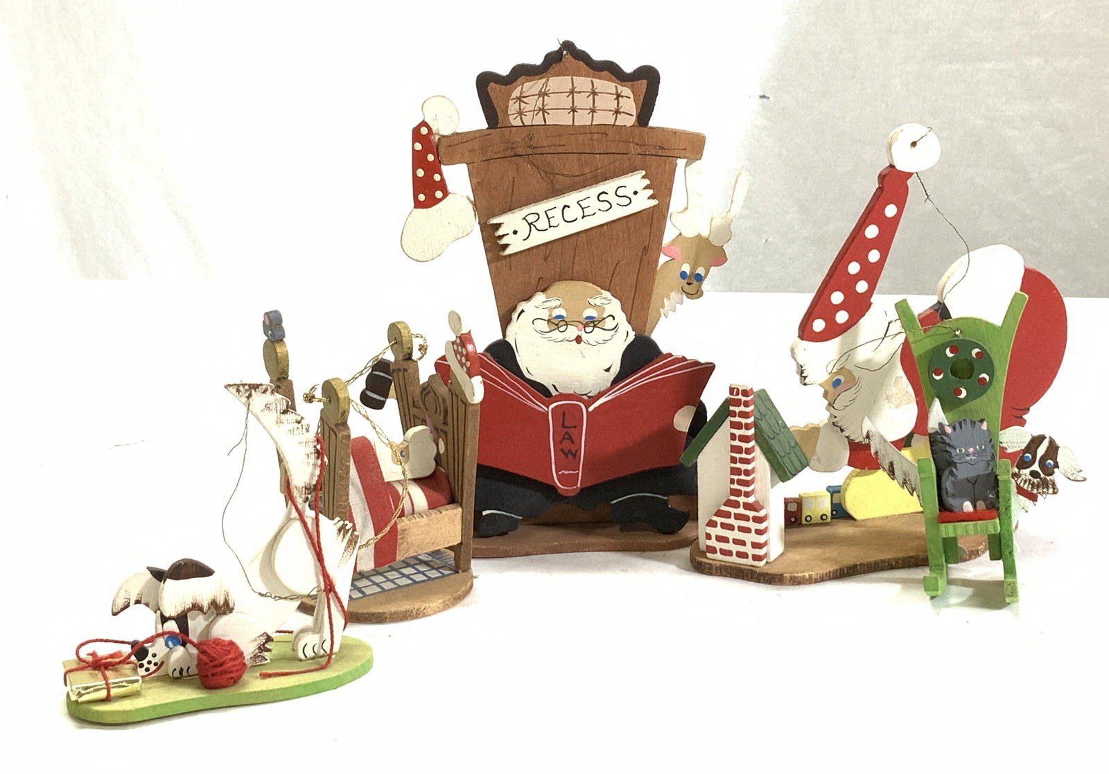 Emgee Painted Wood Christmas Ornaments,5: Santa and animal Christmas tree ornaments. Hand painted wood. 3 are marked Hawaii. 2 are Stamped Emgee Corp. and Hawaii. c. 1974. Largest ornament is Santa reading a law book with the reindeer looking