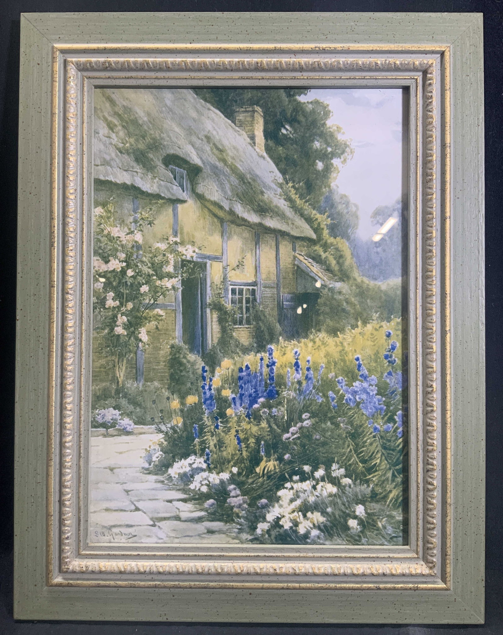 Framed English Countryside Lithograph: lithograph on paper. Signed in print. Subject depicts a look at an English style house with wildflowers outside. Framed in wooden frame with gilt accents. Framed by Guy Grande framing. Frame measures 