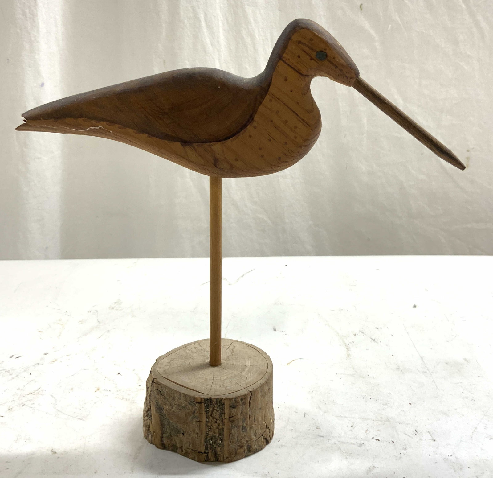 Signed Vntg Curlew Bird Wood Carving Figural: Underside is signed illegibly. Figure is wooden. Wood carved depicts a curlew bird figure. Piece has light brown and tan tones. Figure has base which resembles tree log. Piece measures approximately 9