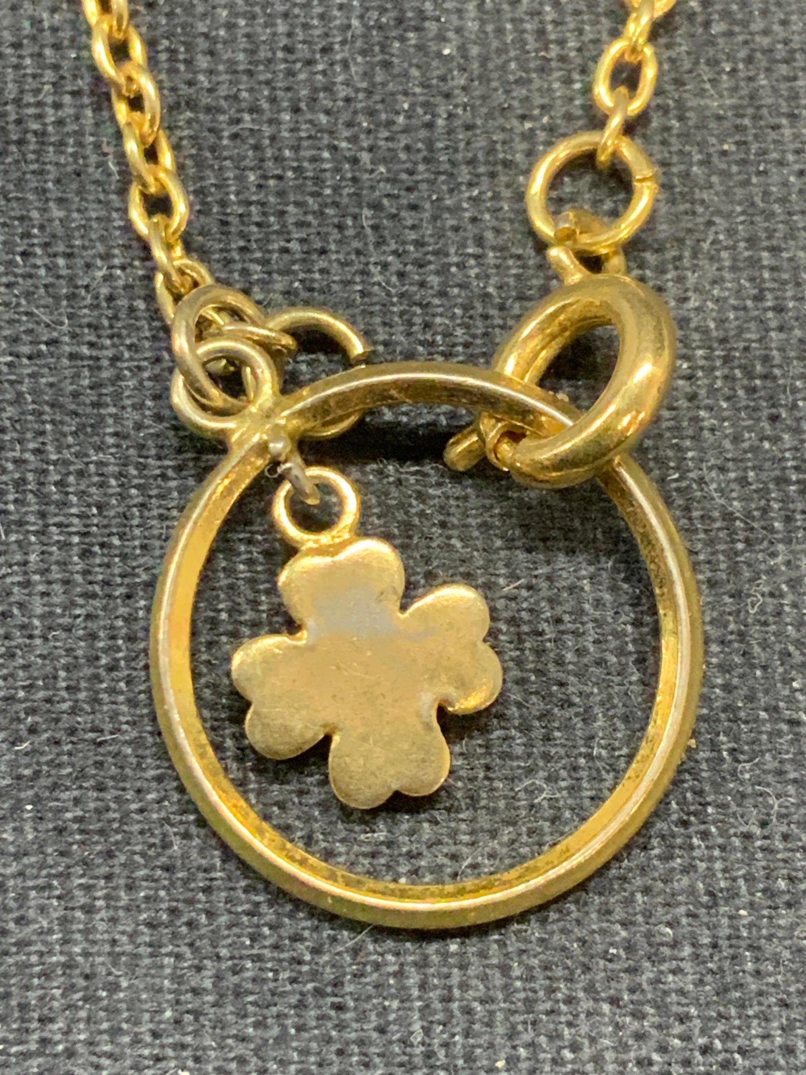 Gold Tone Clover Pendant Necklace: Gold tone necklace with open circle clover motif pendant. Drop length approx. 7 inches. Some surface wear including scratching observed. Estate jewelry, costume jewelry, fashion jewelry, cocktail jewe