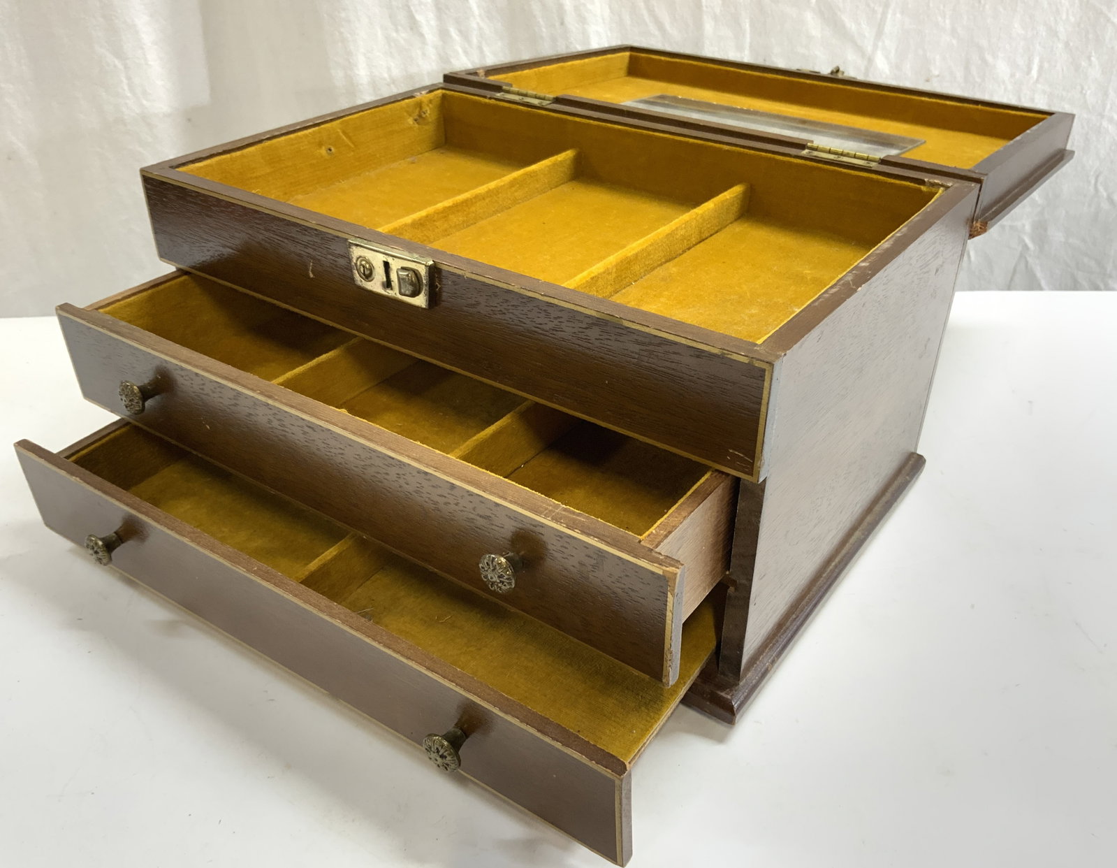 KELLERMAN Vintage Wooden Jewelry Chest W Lid: Locking mechanism is inscribed K. Tag on underside reads KELLERMAN. Jewelry chest is brown toned and wooden with gilt areas at some edges. Piece has 2 drawers. Top of piece has hinged lid. Center of i
