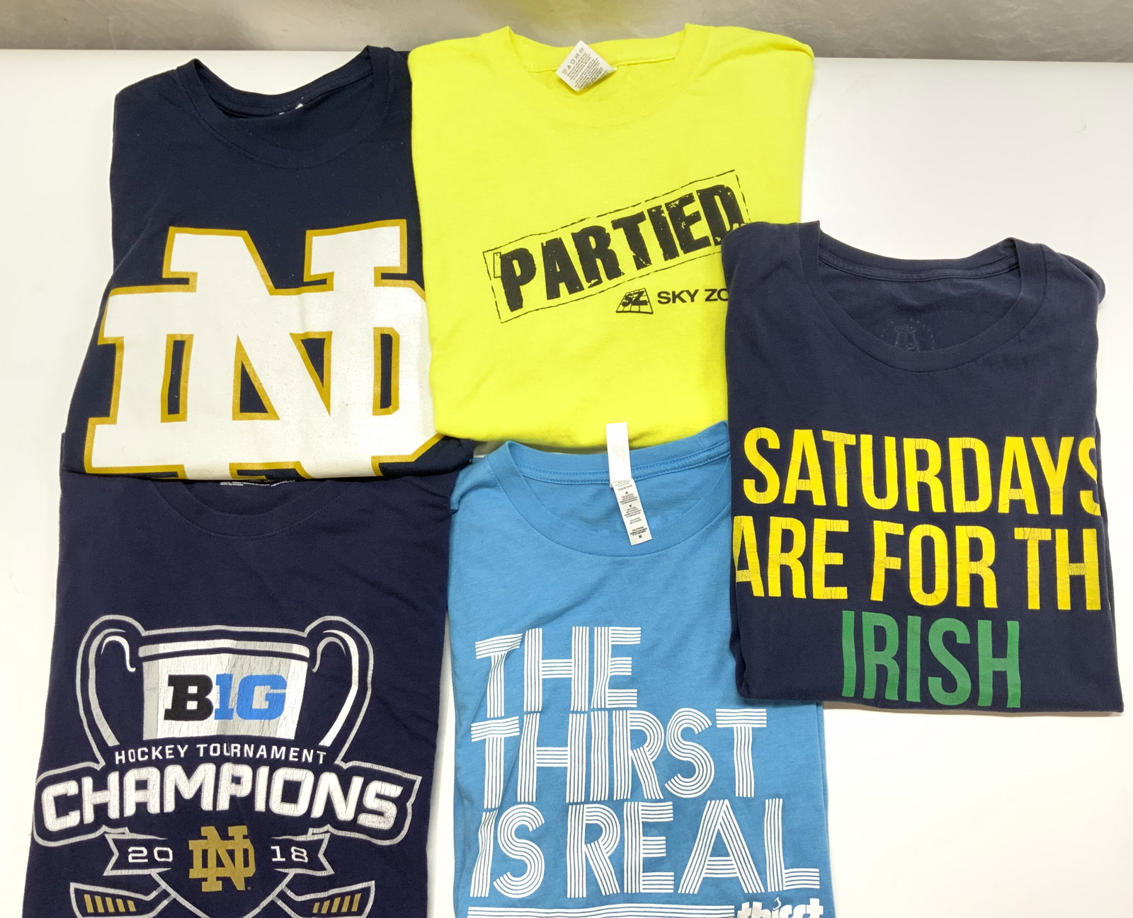 Lot 5 Cotton Blend Graphic Tee - Shirts: Vintage shirt sleeve tee shirts, unisex wear. Sizes are in womens sizes. 2 shirts are Notre Dame University Hockey Shirts. Size Medium. Polyester with stretch and/or cotton blend. 1 Graphic has wear.