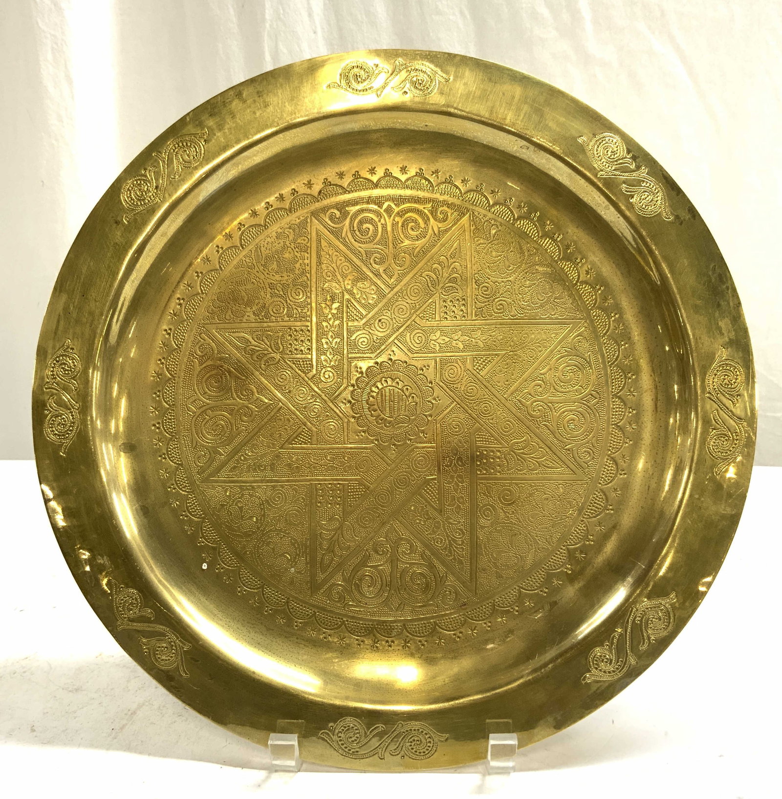 Vintage Brass Moroccan Plate Tray: Tray is gold toned and brass. Piece appears to be Moroccan. Plate is vintage. Piece has ornate scroll vine & leaf relief detail. Center of piece has star form detail. Tray measures approximately 13.5 
