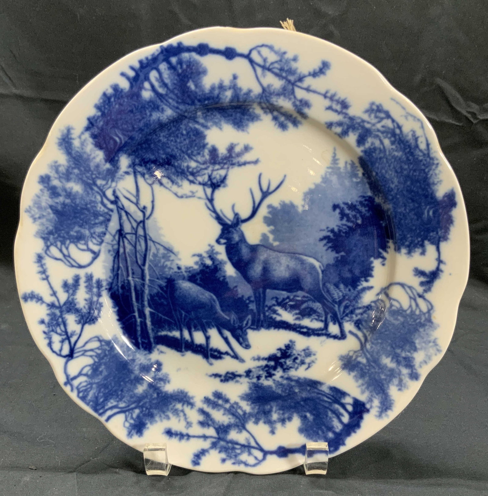 Porcelain Blue & White Wall Plate Hunting Deer: Porcelain ceramic wall plate. Subject on plate is a doe and a buck in an opening in a forest. Image printed on. Plates Diameter approx. 9.5 in. Not viewed hanging. Minor chipping. Provenance on verso 