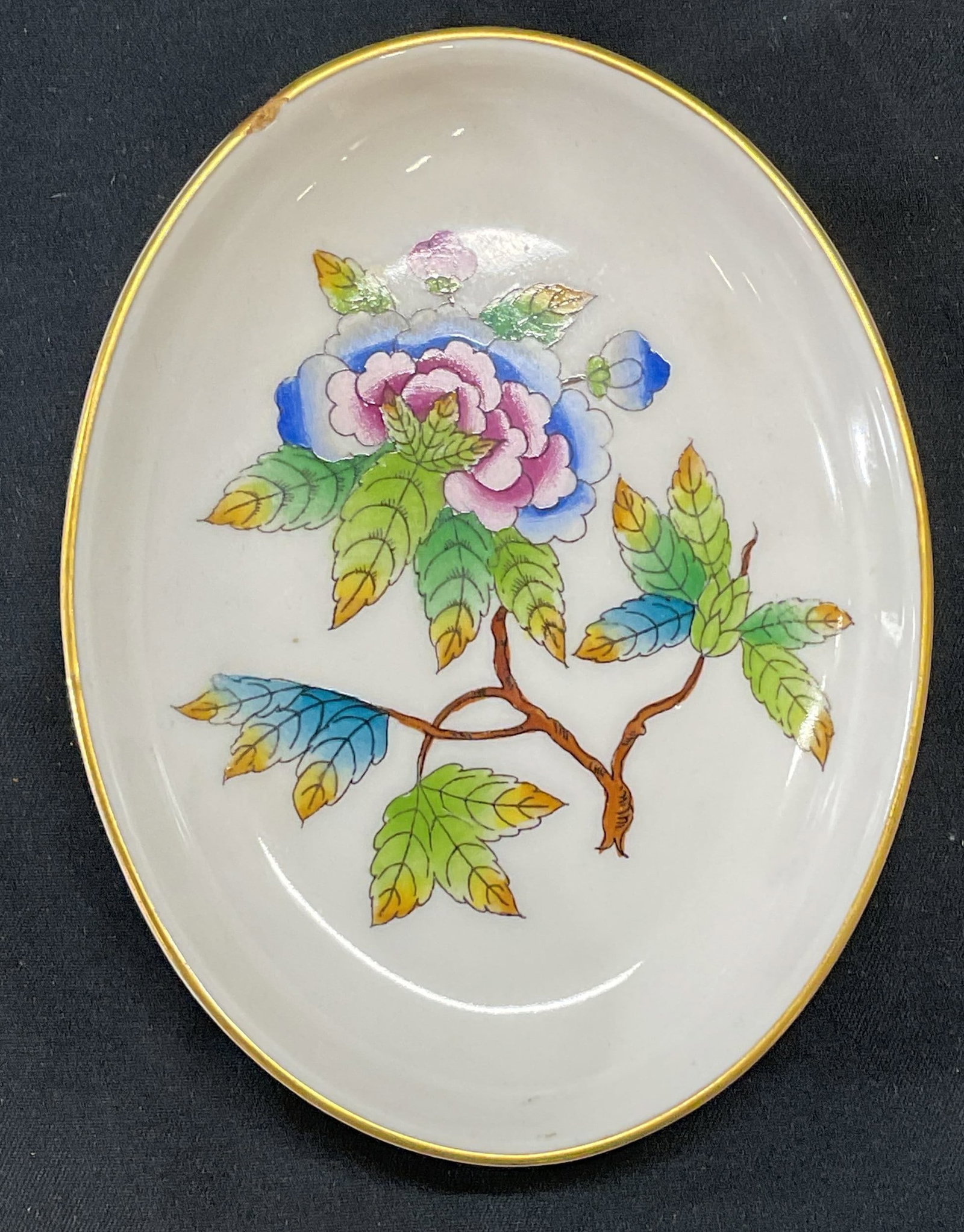 Herend Porcelain Queen Victoria Trinket Dish: Herend porcelain trinket dish in Queen Victoria pattern. Hand painted with floral motif. Gilt decoration. Measures approx. 4.5 x 3.5 inches. Trademarked to underside. Some surface wear including small