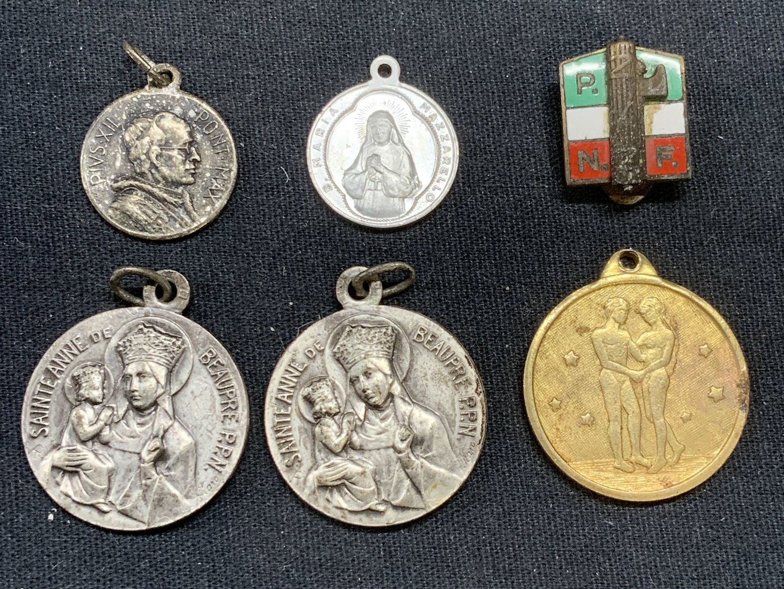 Lot 6 Religious Pendants, Gemini Pendant +: Lot of 6 pendants, includes 4 silver tone catholic religious motifs, 1 Italian Costelli Cerosa accessory, and 1 gold tone Gemini zodiac motif pendant. Largest pendants measure approx. 1 inch wide. Som