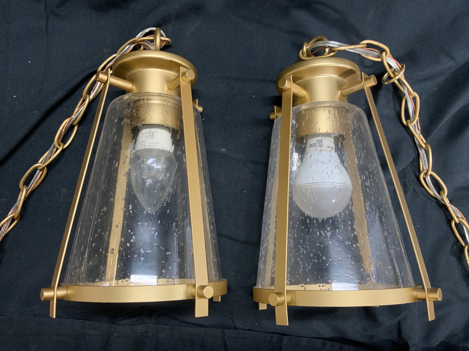 Pair Gilt Metal & Glass Pendant Lamps: Lot Includes 2 pendant glass lamps. Each piece is gilt metal and glass. Pendant lamps each have chain links. Pendant lamps without chain links measure approximately 12 inches tall 6 inches wide. Lamps