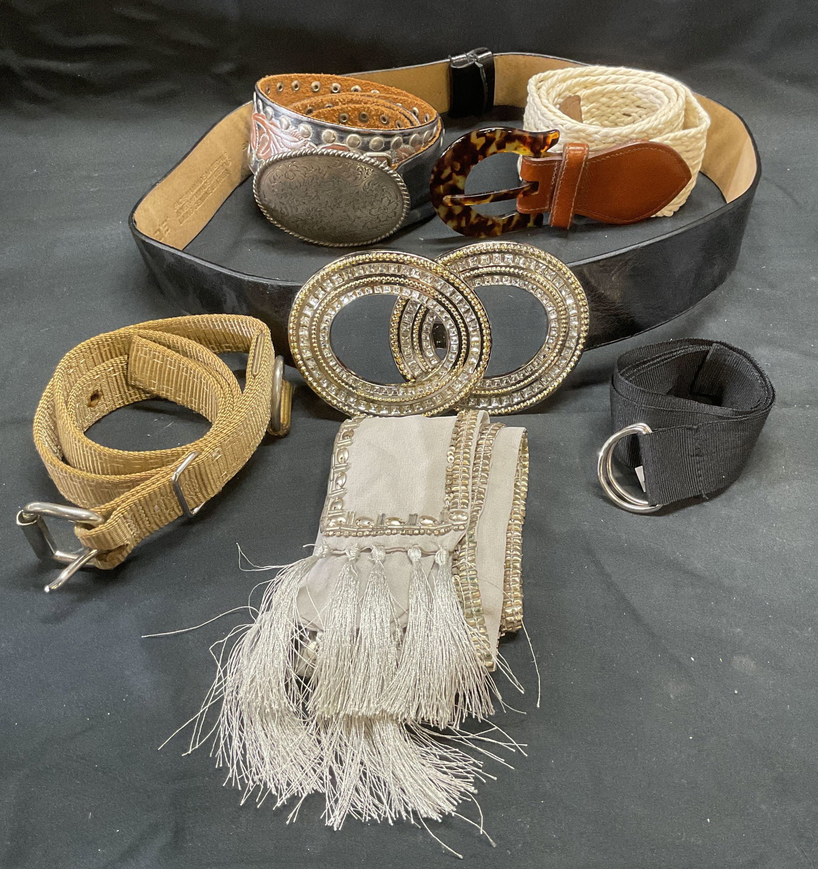 Lot 6 Streets Ahead, Chicos + Leather Belts: Streets Ahead silver and pink leather belt with floral motif. Size large. Chicos black leather and synthetic material belt with crystal statement buckle. Size small/medium. White woven belt with torto