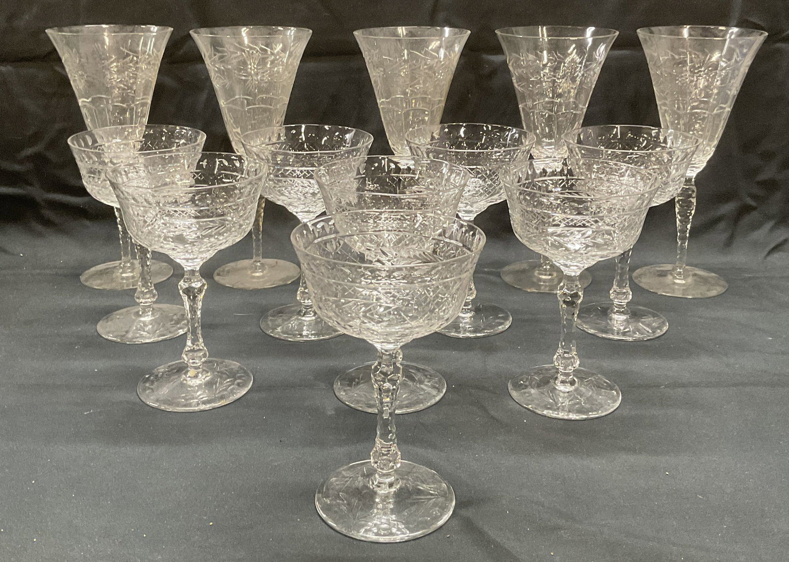 Lot 13 Cut Glass Coupe & Wine Glasses: Set of 8 cut glass coupe glasses with geometric botanical pattern. Measure approx. 3.75 x 5.75 inches. Set of 5 cut glass wine glasses with geometric botanical pattern. Measure approx. 3.75 x 8.25 inc