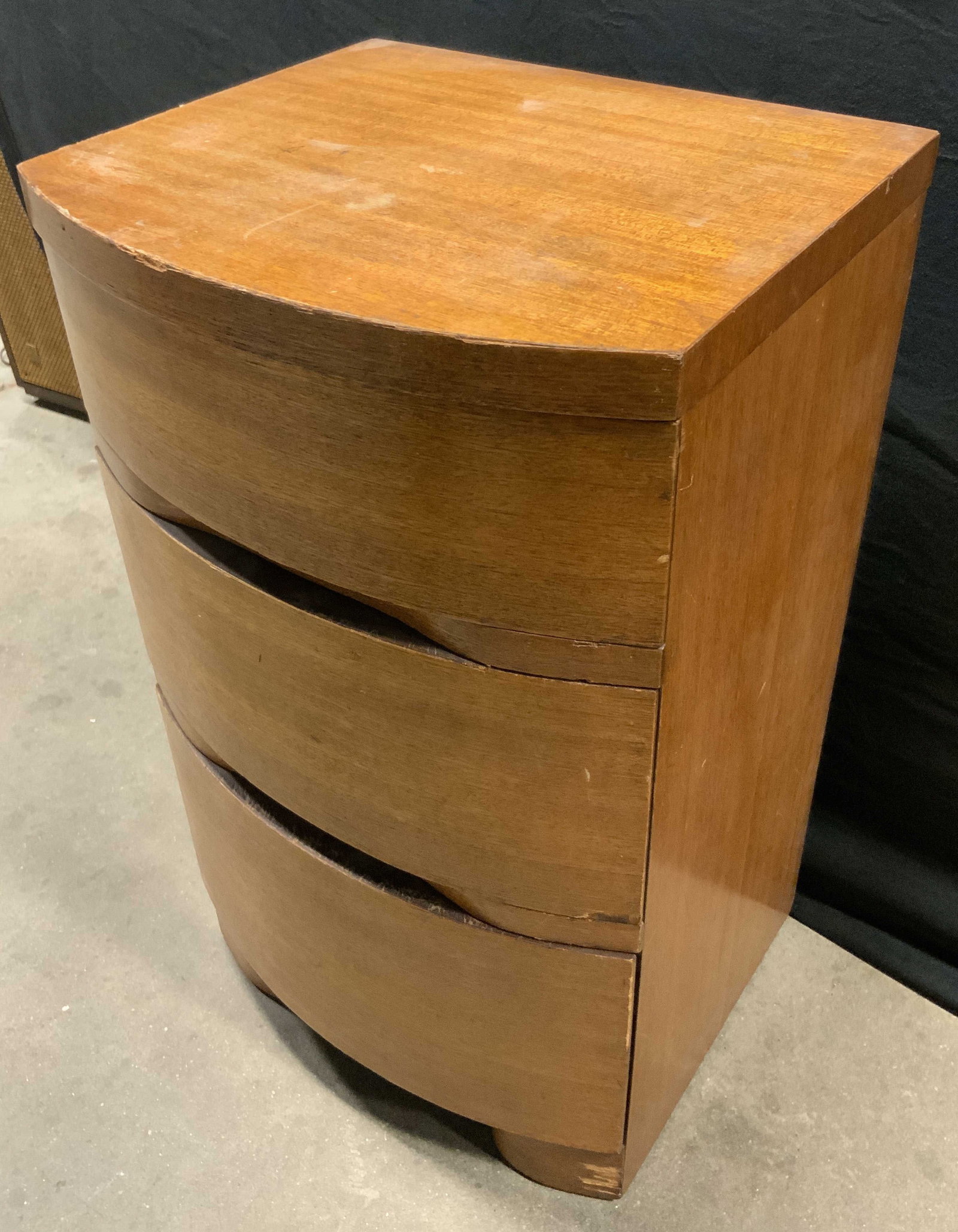 Vintage Mid Century Modern Mahogany Nightstand: A vintage mid century modern mahogany nightstand. Three drawers. Dovetailing to the drawers. Measures approx. 27.5H x 14D x 16W in. Sticker to reverse reads MANUFACTURERS DESIGNATION, Wood- Light Maho