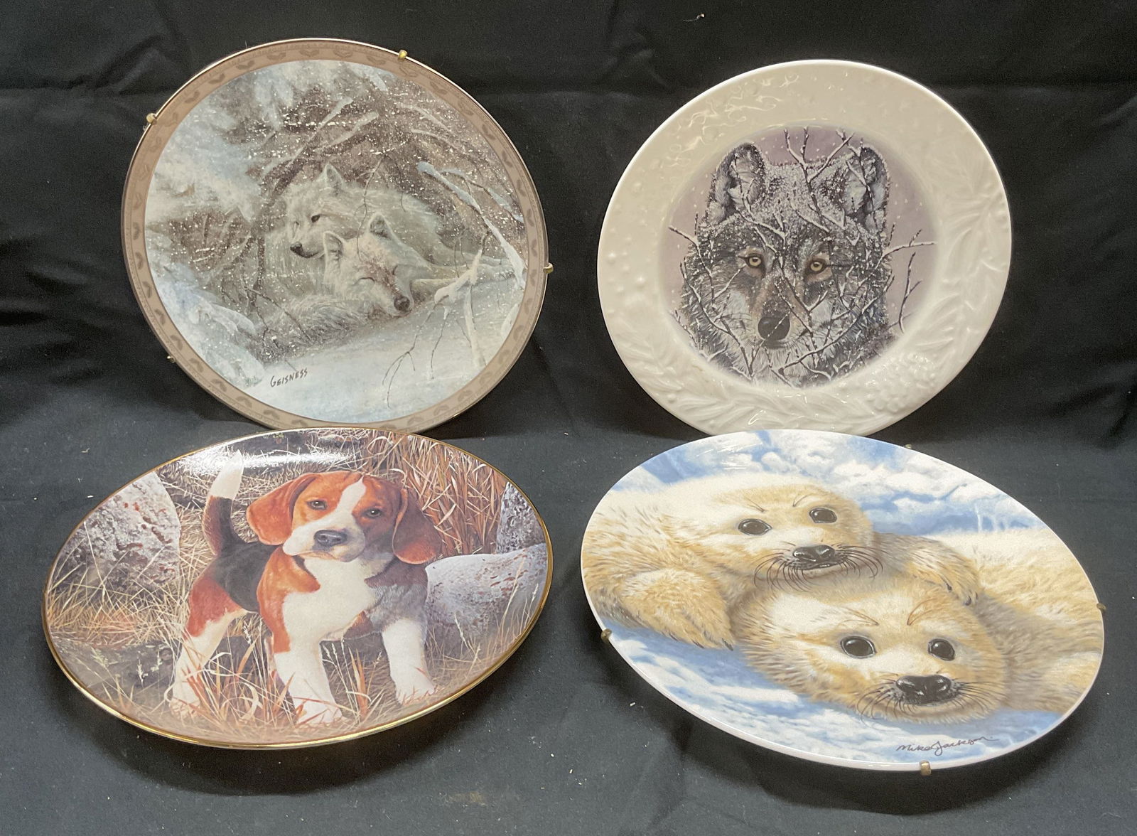 Lot 4 Danbury Mint, Bradford + China Art Plates: Lot of 4 fine china art plates. The Danbury Mint Beagles edition art plate. Dog motif. Signed to underside. The Bradford Exchange Peace on Earth series and The Veil of Winter series art plates. Wolf m
