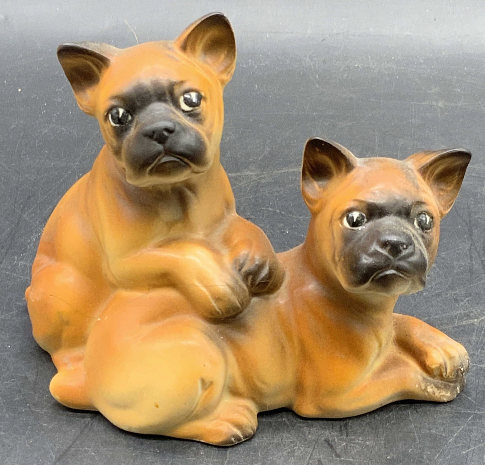 Vintage Brown Ceramic Boxer Puppies Figural: A vintage brown ceramic boxer puppies figural. The figural depicts two boxer puppies, one rests atop the other. Underside numbered 1555. Drilled hole to underside. Measures approx. 3.75H x 5W in. Crac