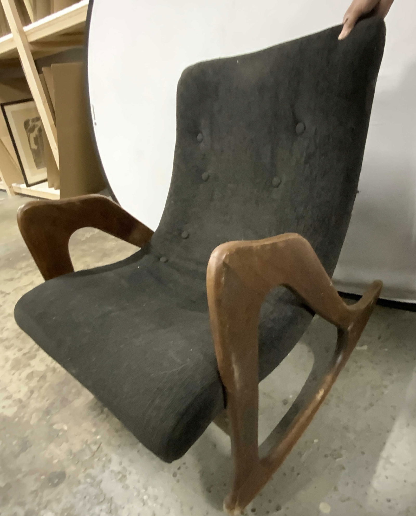 EKORNES MCM Uph Lounge Chair W Wood Supports: Chair appears to be EKORNES (no apparent markings). Chair is upholstered with black toned fabric. Chair is tufted. Piece has 2 brown toned wooden supports. Measures approximately 33.5 inches tall 26 i
