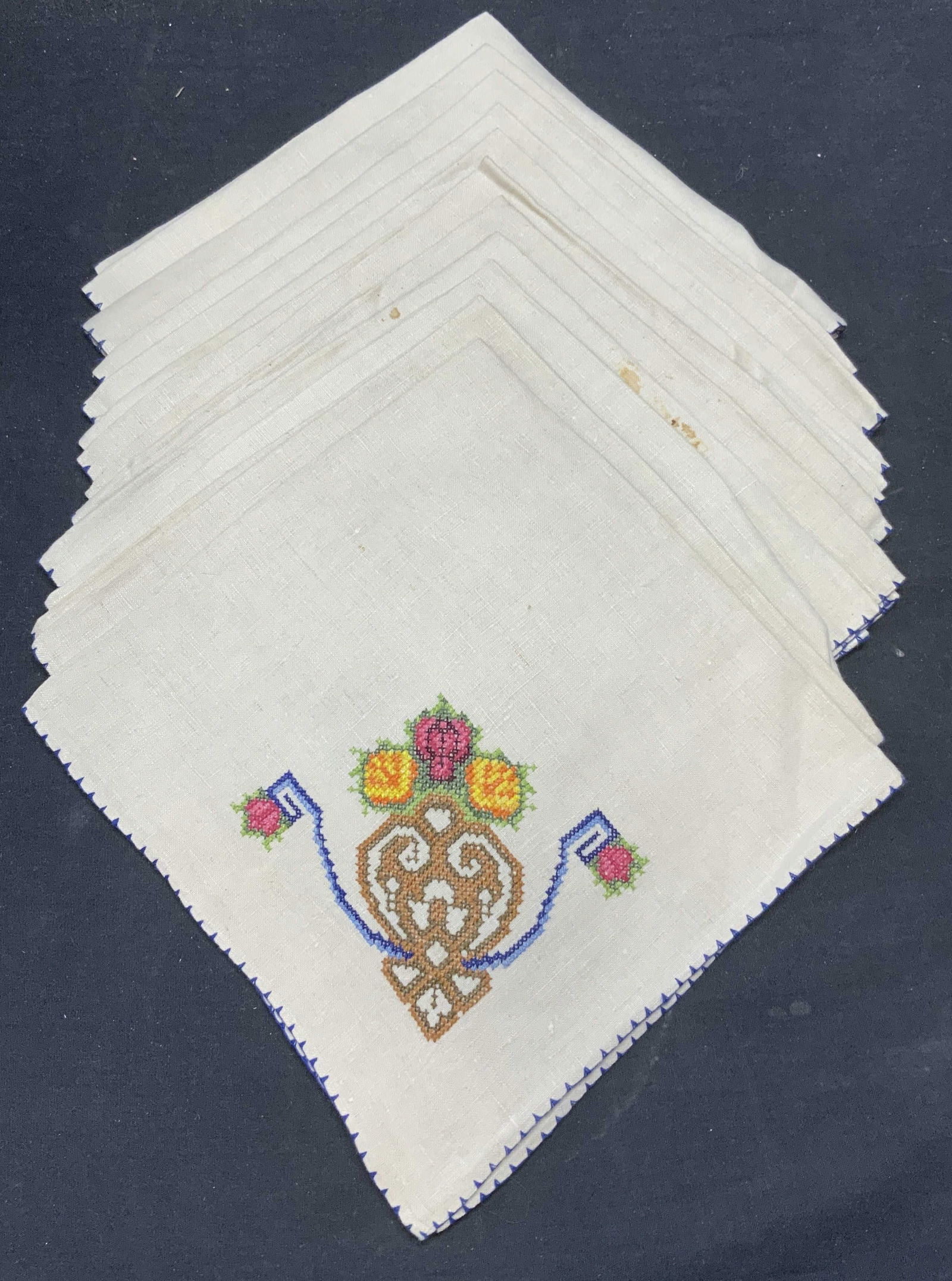 Set 11 Beige Linen Embroidered Floral Napkins: Set of 11 beige napkins. Embroidered cross stitch decoration with floral motif. Measure approx. 19 x 20 inches each. Material feels like linen. Some pieces have wear to material including blemishes ob