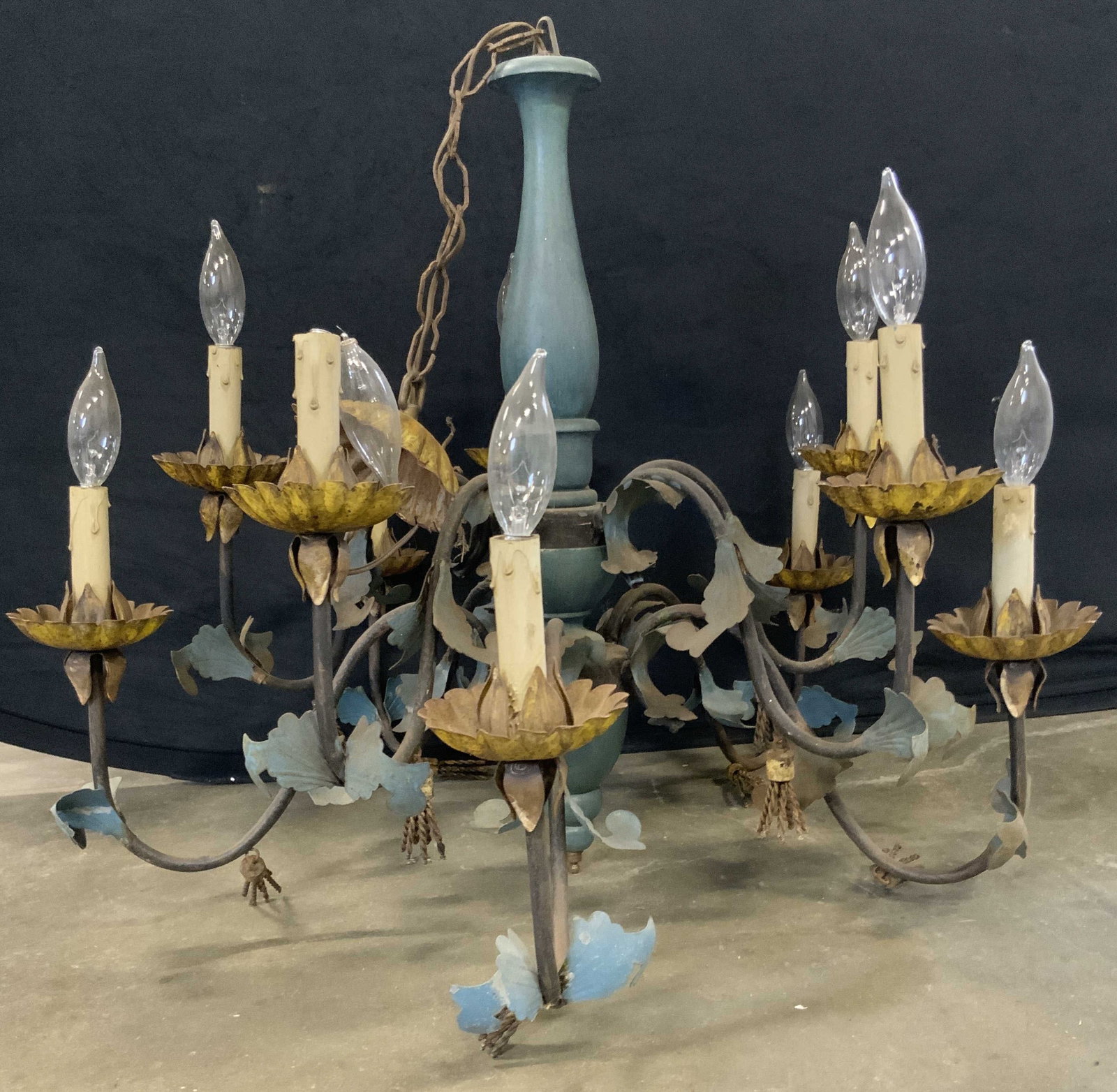 Vintage Scrolled Ten Arm Wood & Metal Chandelier: A vintage wood and metal chandelier. Scrolled metal arms with floral & foliage motifs. Ten arms. Metal tassel accents to the arms. Center features blue painted wood. Chandelier measures approx. 22.5L 