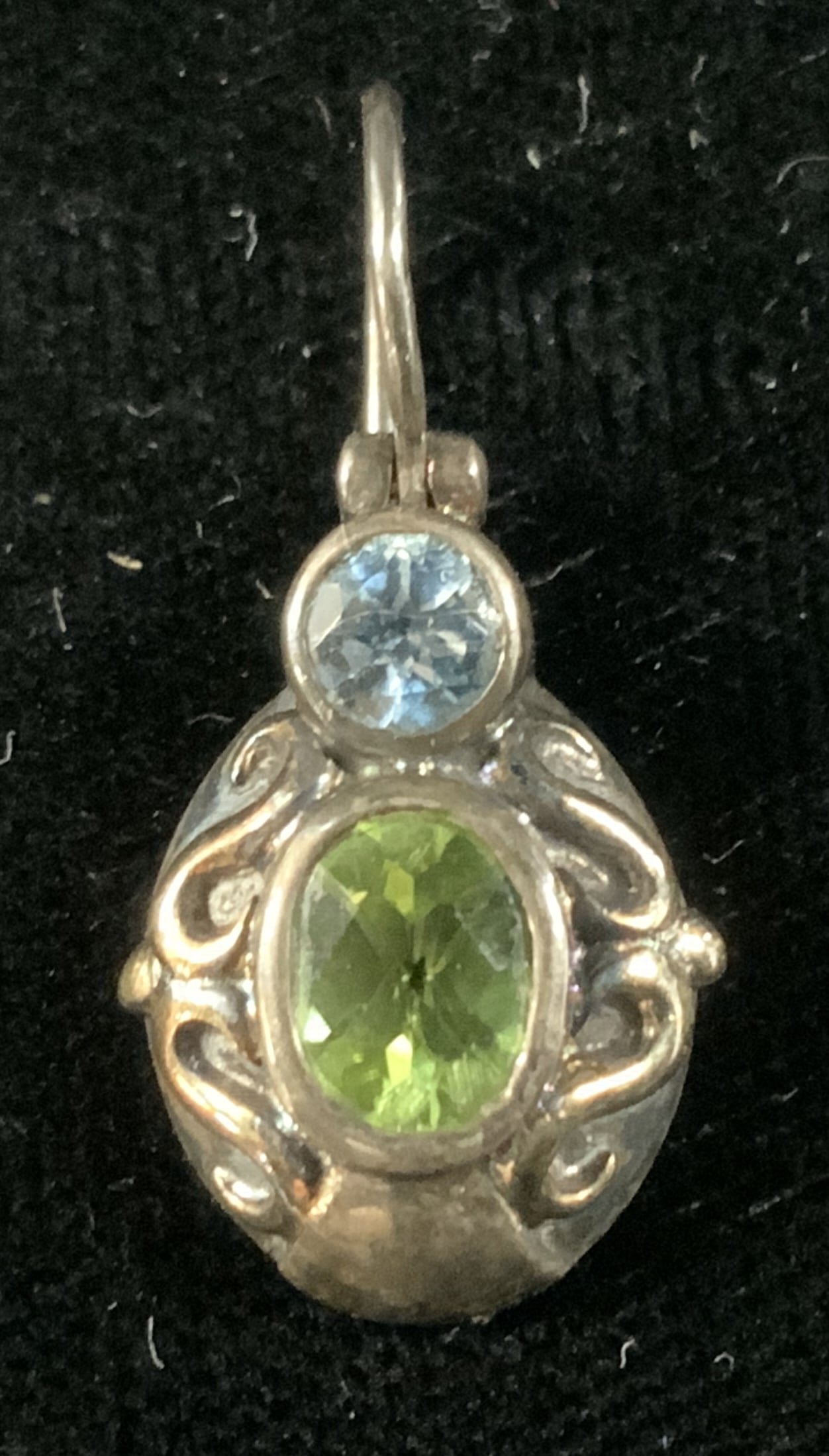 Sterling Silver/14k Gold Gemstone Earring: Single dangle earring made of 925 sterling silver with a 14 karat gold design accent. Reverse of earring reads 925 and 14 k. Gemstones in the earring are peridot and blue topaz. Measures approx. 75L x