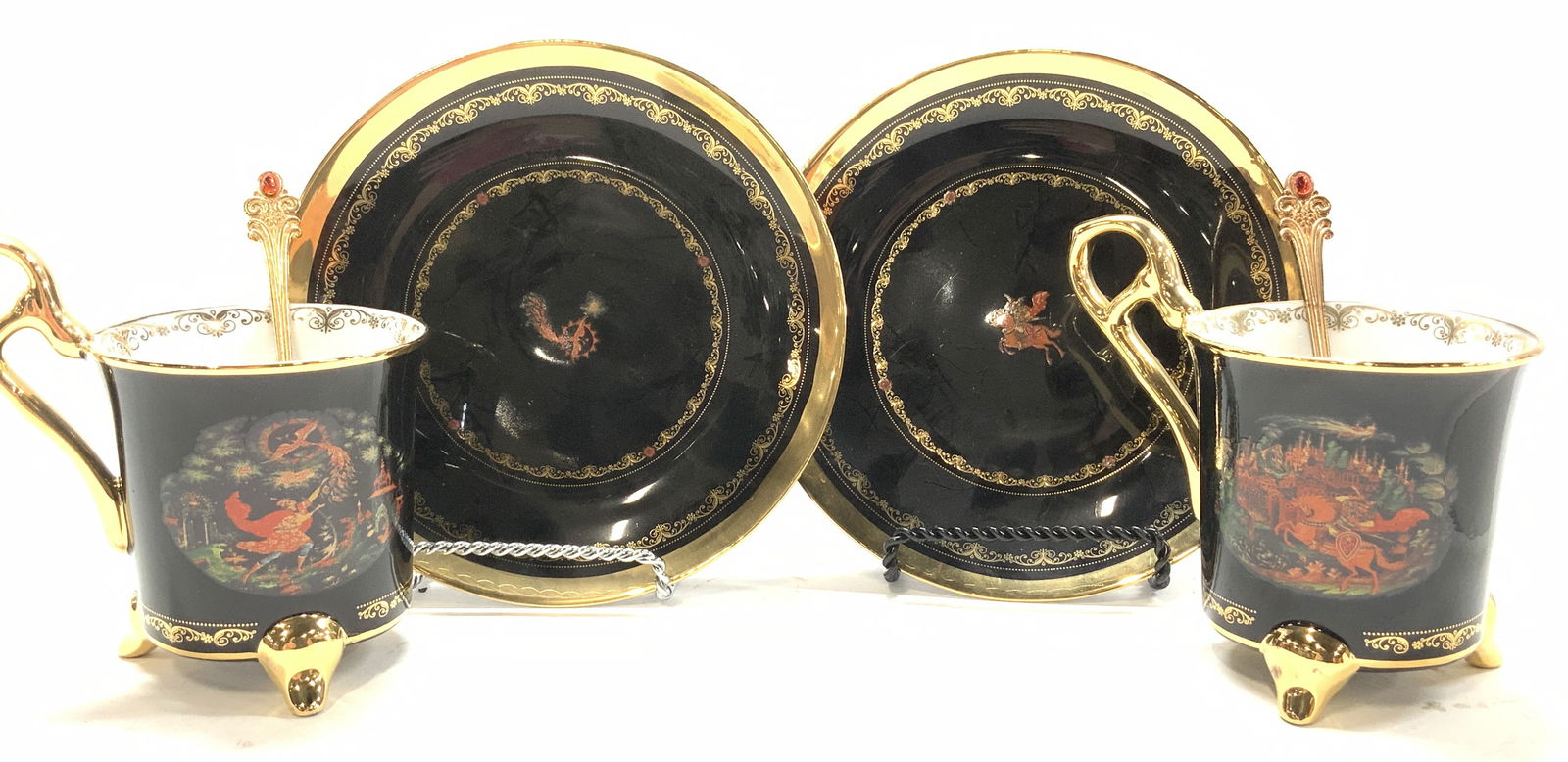 Set 6 BE Russian Porcel Tea Cups, Saucers, Spoons: Hand painted Bradford Editions Russian motif Tea cups, saucers, and spoons. Series by BE. The Firebird A1704 and Ruslan & Ludmilla A3728. All black with gilt. Gold tone spoons. Footed cups measure 4 i