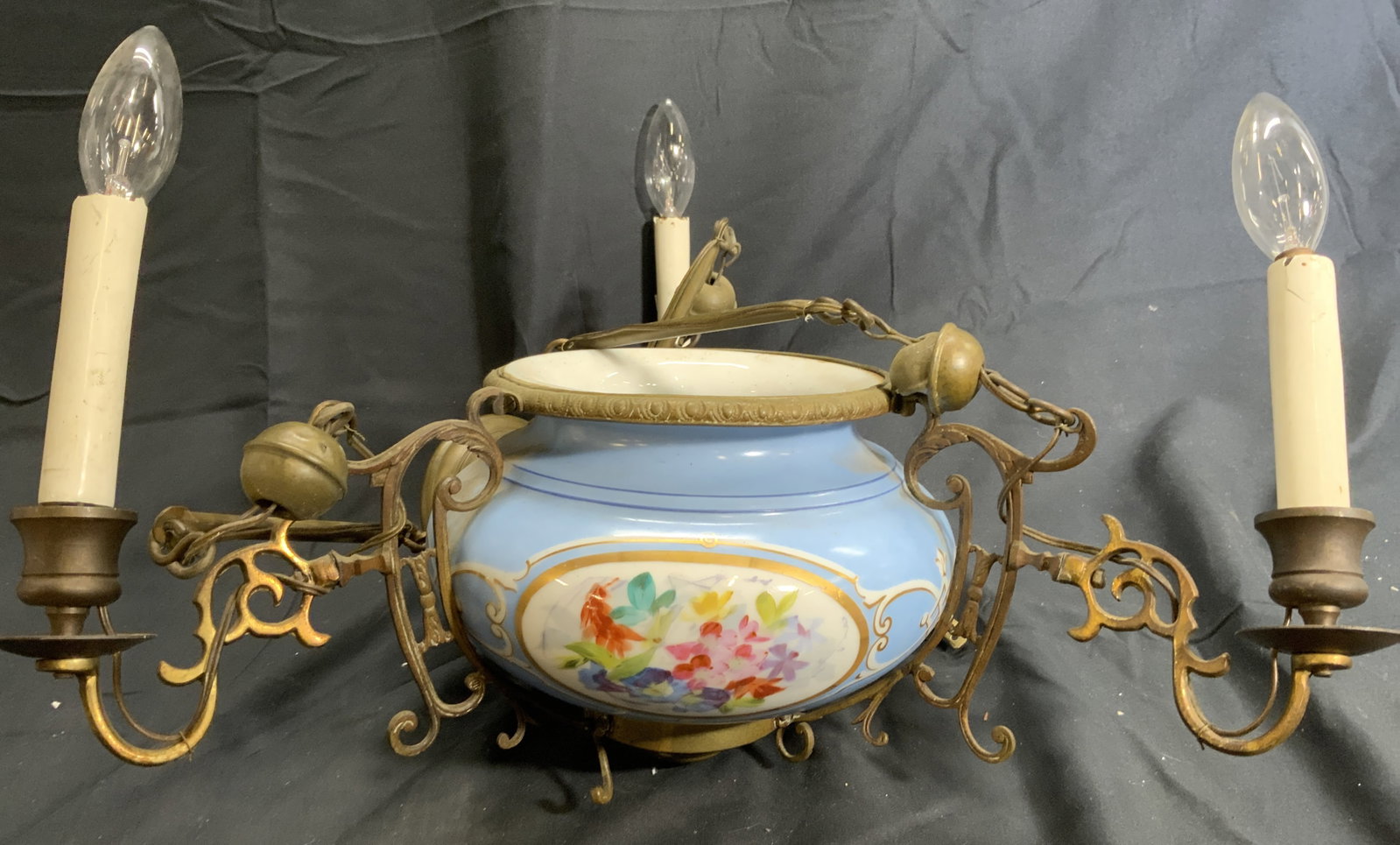 3 Arm Art Glass & Brass Chandelier: Chandelier is glass and brass. Piece has 3 gold toned ornately detailed brass arms. Piece has art glass center with floral & leaf detail. Chandelier measures approximately 18.5 inches tall 17 inches w
