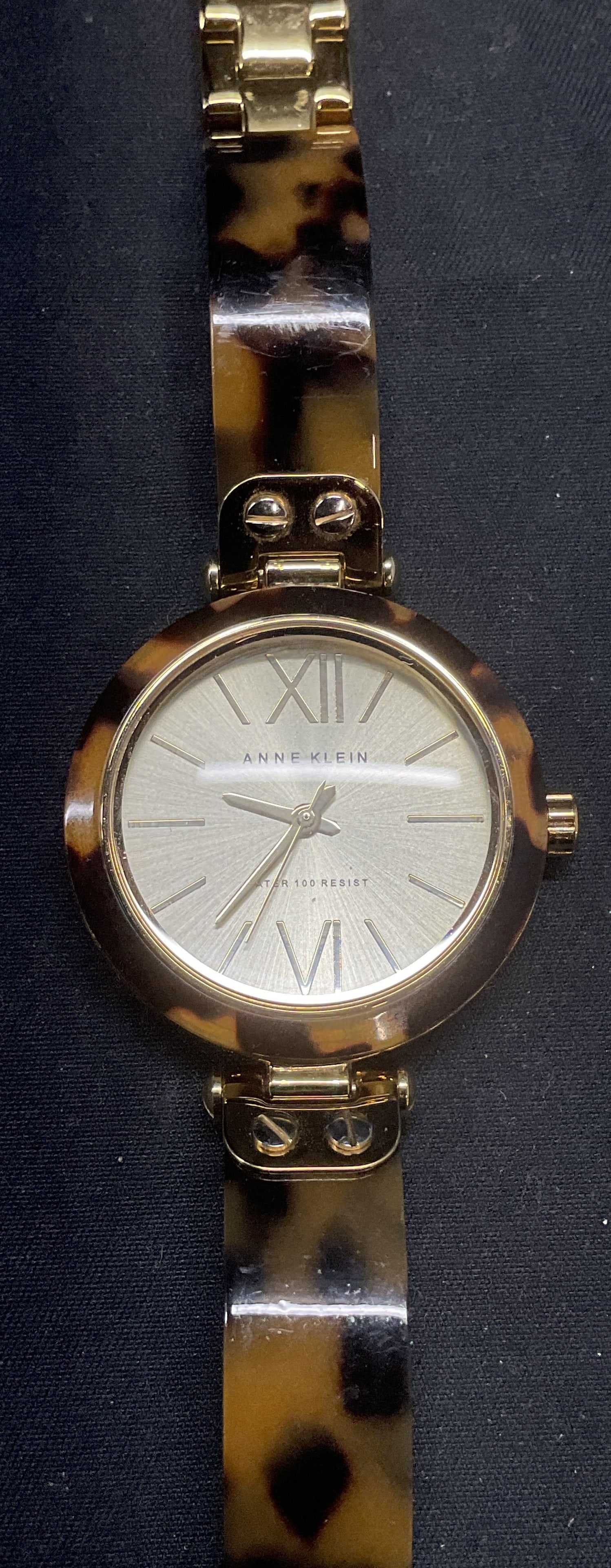 Anne Klein Gold Tone Watch: Anne Klein gold tone watch with tortoise shell acrylic detail. Signed in watch face. Measures approx. 7 inches long. Not tested for function. Some surface wear including scratching observed. Jewelry, 