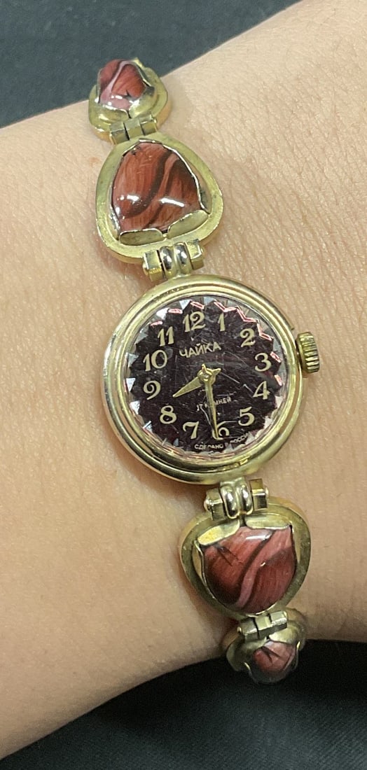 Vintage Hanka Russian Gold Tone Watch: Vintage Hanka Russian gold tone watch with purple cabochon panels. Signed on watch face. Measures approx. 7 inches long. Not tested for function. Some surface wear including scratching observed. Jewel