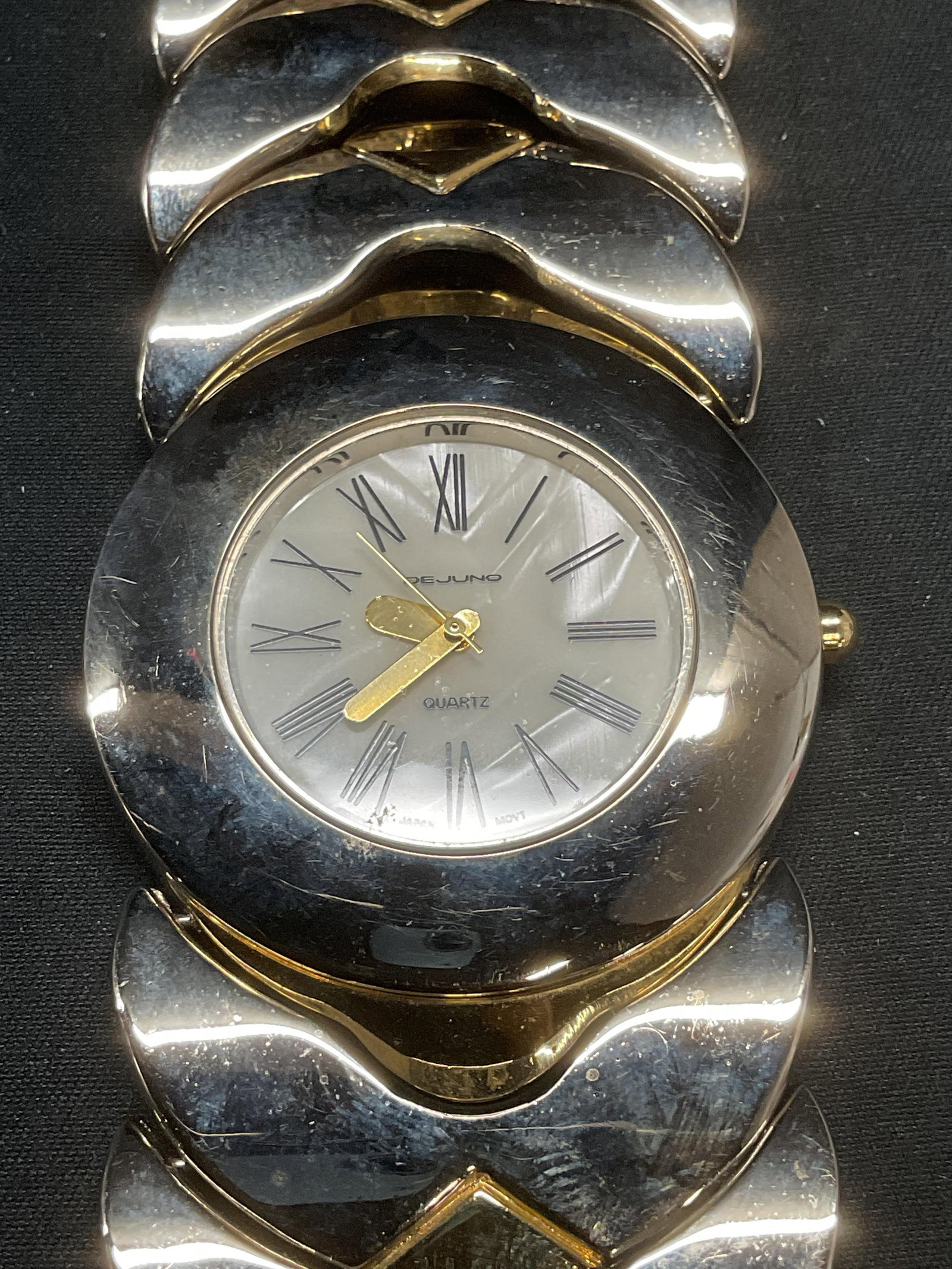 Vintage Dejuno Silver Tone Bracelet Watch: Vintage Dejuno silver and gold tone bracelet watch. Signed on watch face. Measures approx. 6.75 inches long, band approx. 1.5 inches wide. Some surface wear including scratching observed. Not tested f