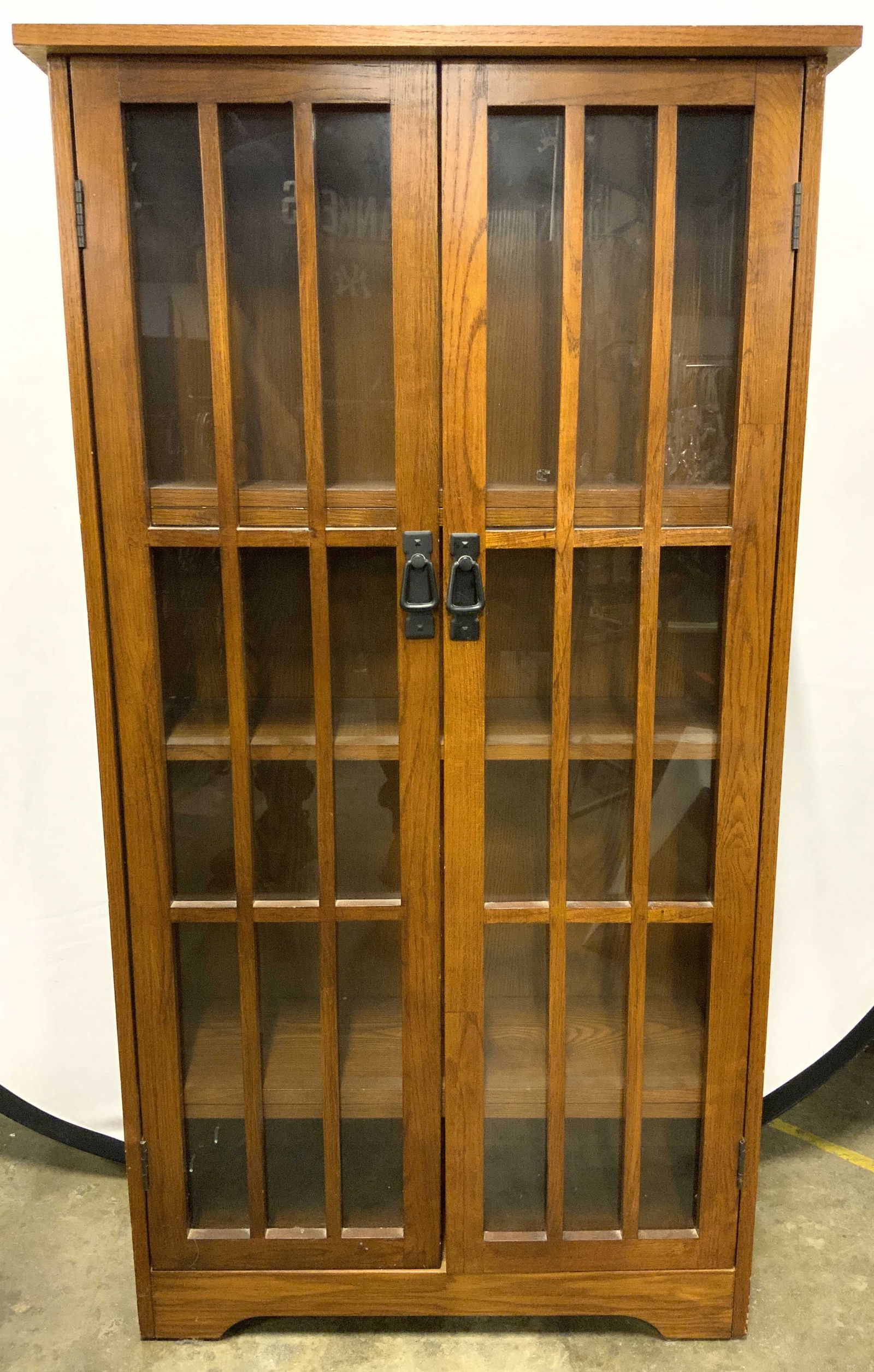 Wooden Display Cabinet W 5 Shelves: Cabinet is tan toned and wooden. Piece has glass windows to doors. Interior has 5 wooden shelves. Front of piece has double cabinet door. Measures approx 48 inches tall 26 inches wide 9 inches deep. P