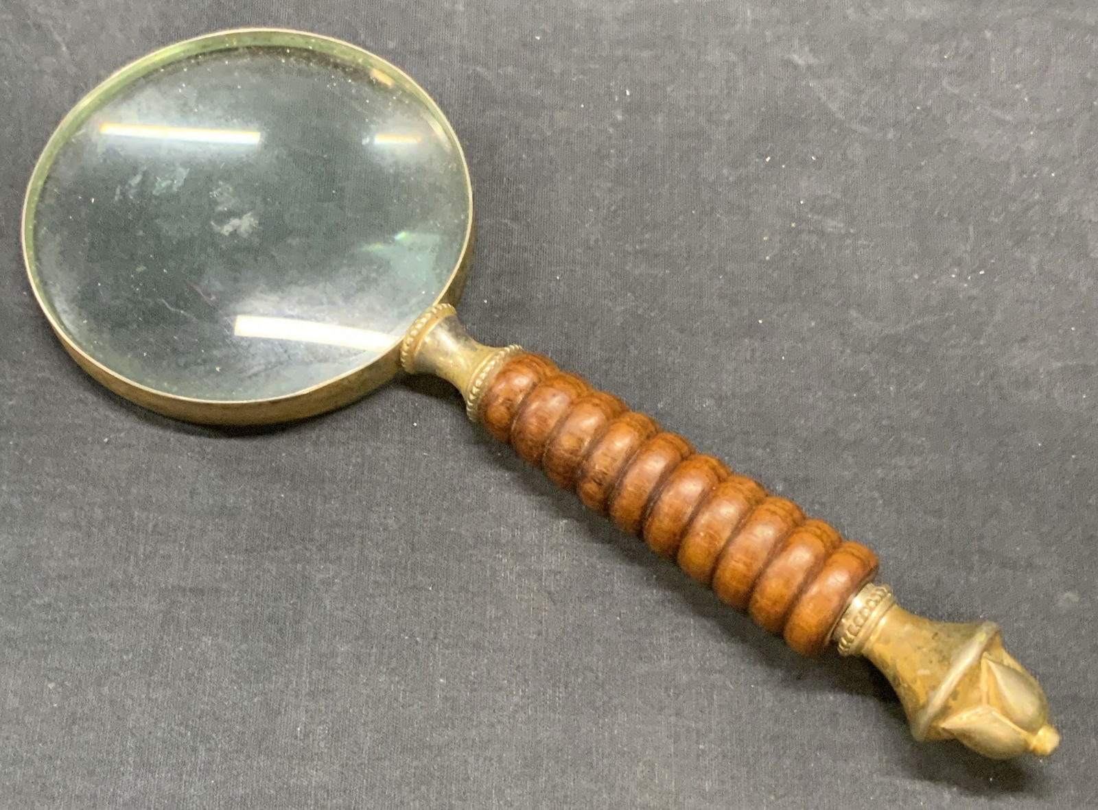 Vintage Wood Handled Magnifying Glass: A vintage wood handled magnifying glass. Carved wood handle is tipped with a raised metalwork accent. Measures approx. 10.25L x 4W in. Some discoloration and surface wear present. Collectibles, vintag