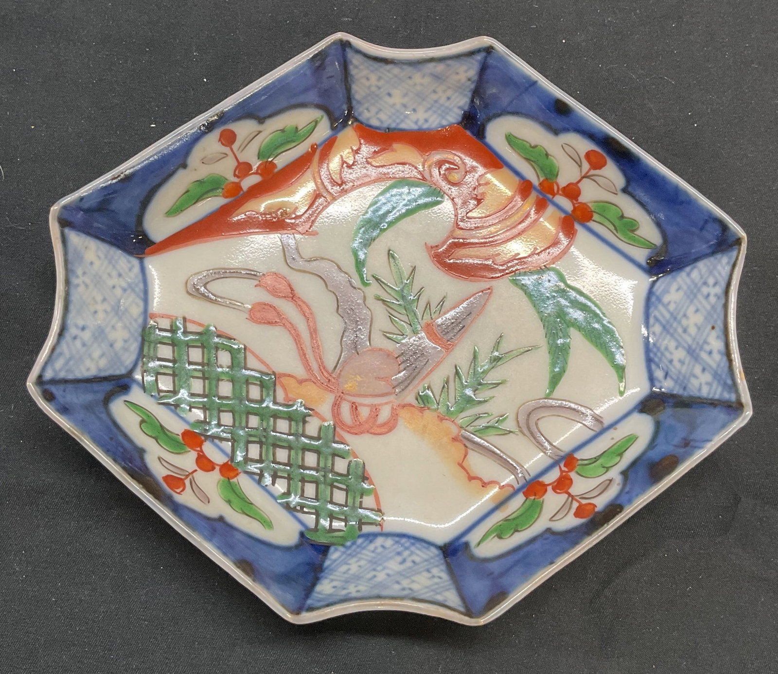 Antique Imari Porcelain Octagonal Dish: Antiques Asian Imari porcelain dish. Octagonal shape. Hand painted in hues of blue, red, and green with botanical motif. Measures approx. 6.25 x 5.5 x 1.5 inches. Some surface wear including scratchin