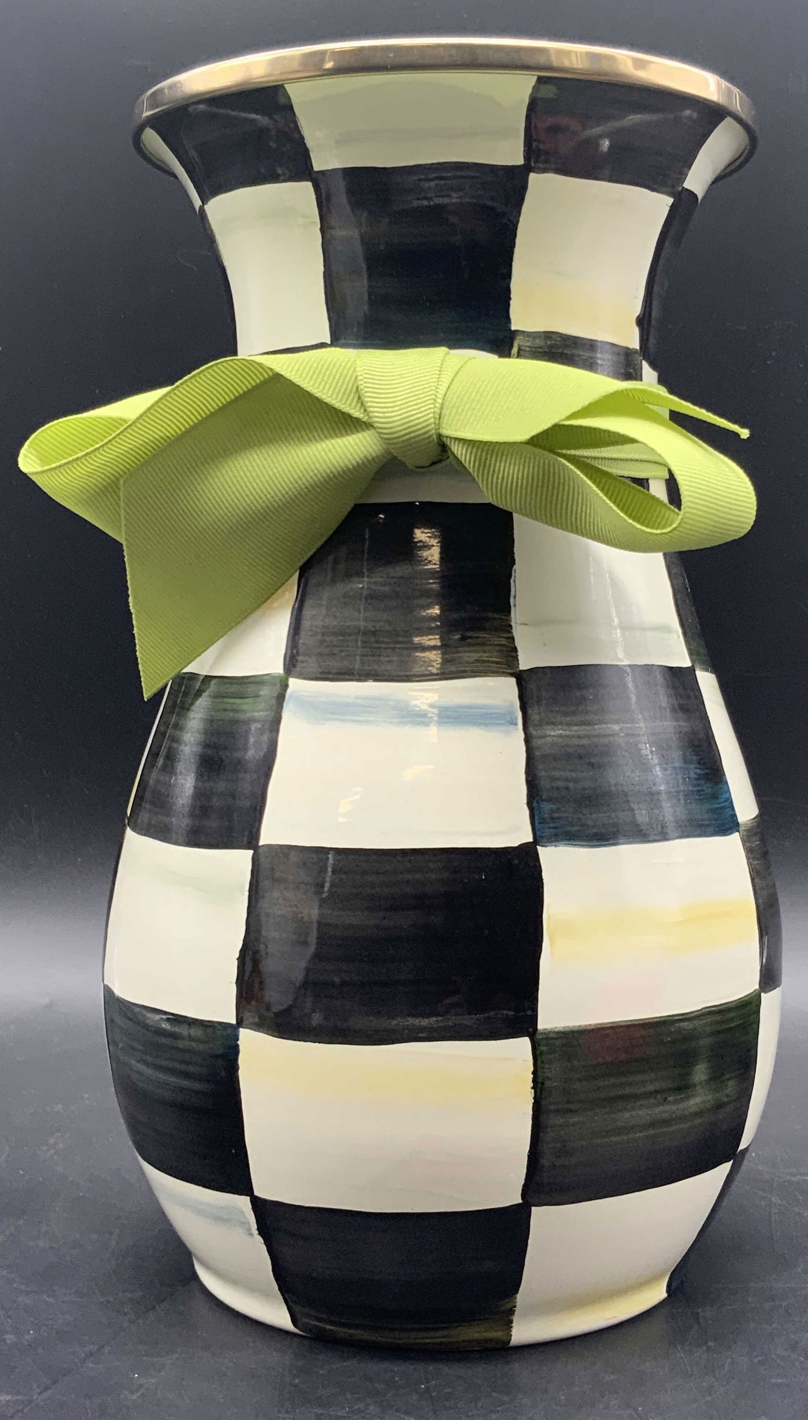 MACKENZIE CHILDS Courtly Check Enamel Vase: A MACKENZIE CHILDS courtly check enamel vase with green fabric ribbon. Measures approx. 10H x 5.5W in. Stickers to the underside. Underside signed MACKENZIE CHILDS. Some surface wear consistent with a