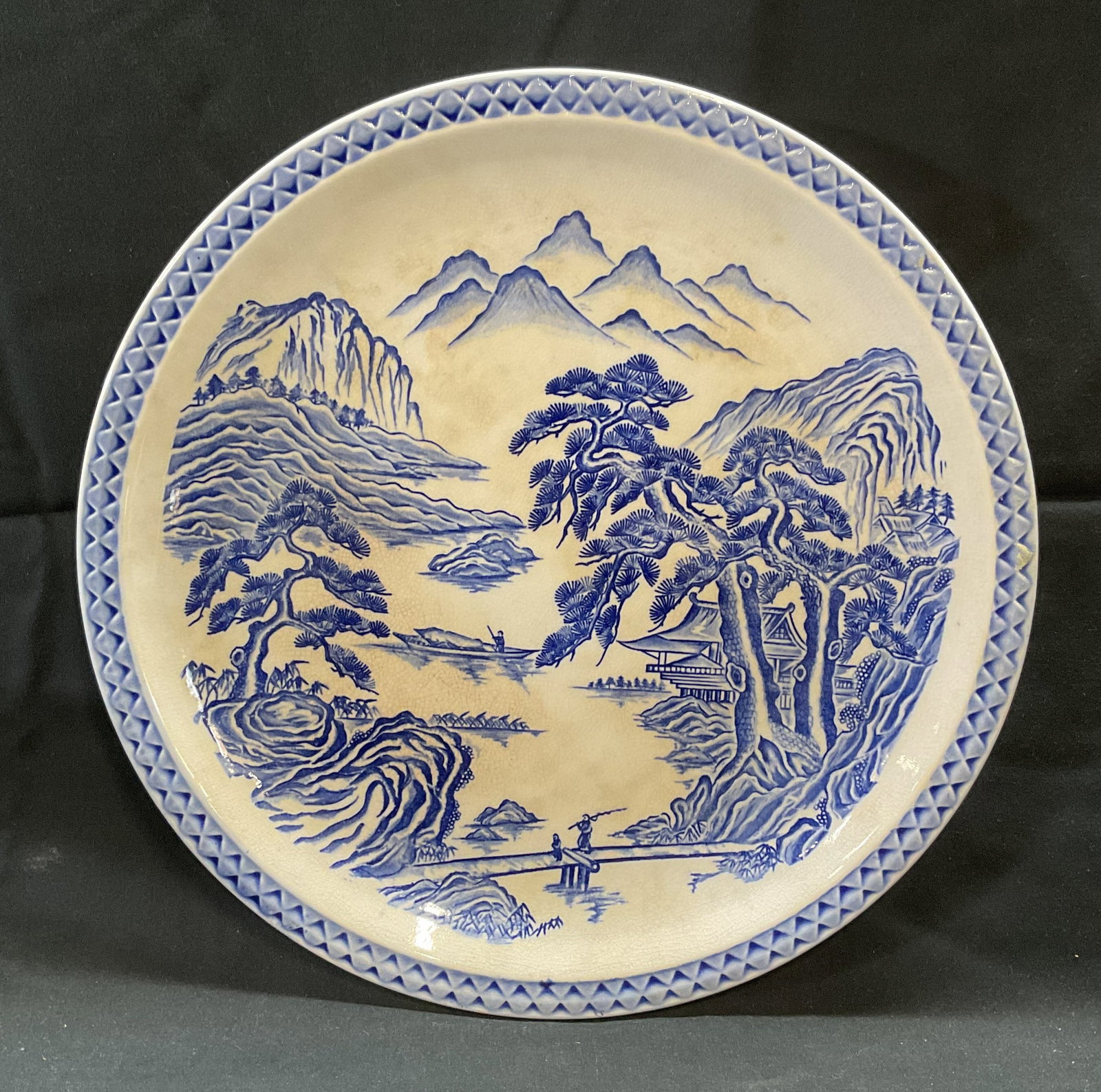 Vintage Porcelain Pine Mountain Charger Plate: Vintage porcelain charger plate. Pine Mountain pattern. Asian landscape motif in blue and white. Measures approx. 12.5 inches diameter. Some surface wear including scratching and crazing observed. Pin