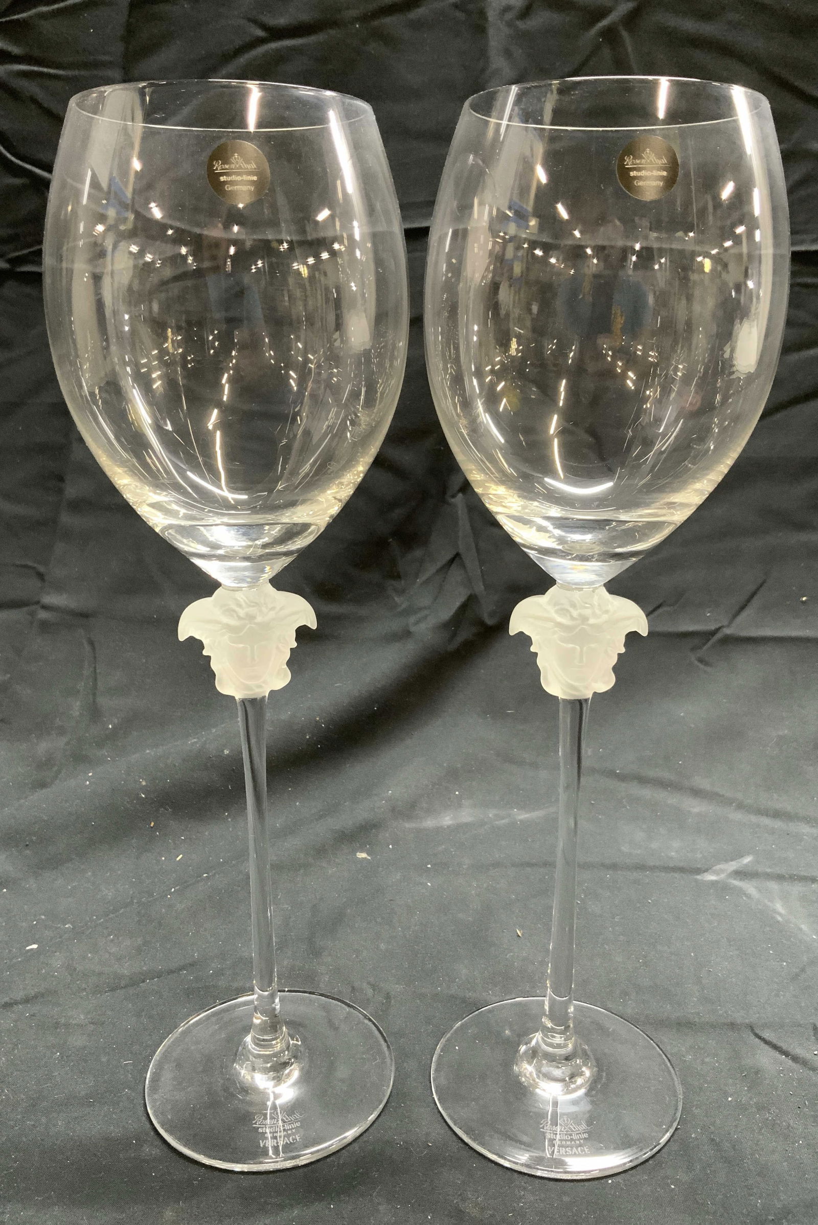ROSENTHAL VERSACE Pr Crystal Wine Glasses: Bases & Tags read ROSENTHAL STUDIO LINIE GERMANY. Bases also read VERSACE. Each wine glass is crystal. Tops of each stem have Versace Medusa head. Each piece of stemware measures approximately 11 inch