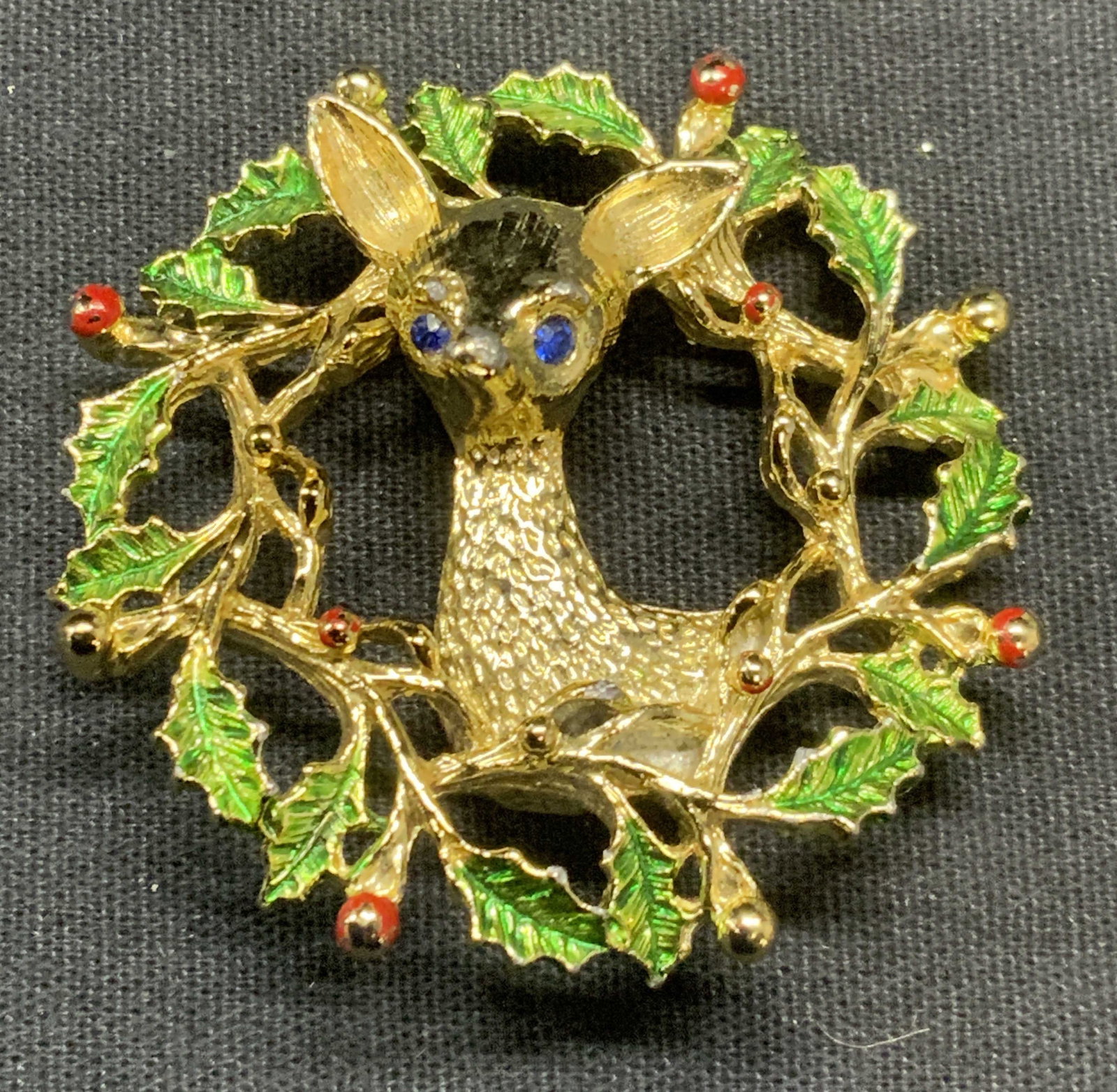 Vintage Gerrys Gold Tn Deer & Holly Wreath Brooch: Vintage Gerrys gold tone enameled brooch. Sculptural deer and holly wreath motif. Signed to underside. Measures approx. 2 inches diameter. Some surface wear including scratching observed. Estate jewel