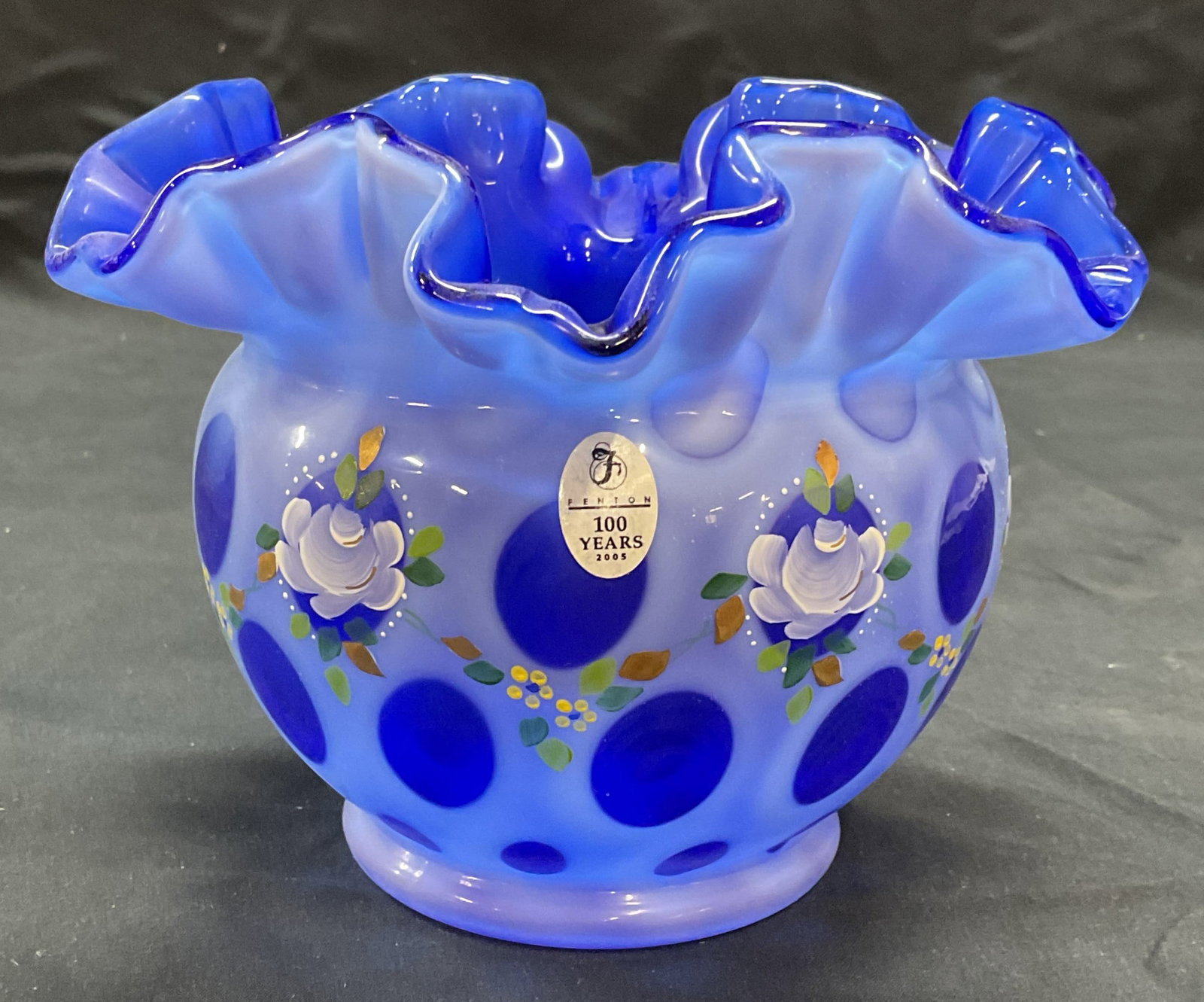 Fenton Art Glass Blue Coin Dot Rose Bowl: Fenton cobalt blue art glass rose bowl. Coin dot pattern with handkerchief rim. Hand painted with floral motif and gilt detail. Marked Fenton on sticker and underside. Signed by Fenton artist M. Kibbe
